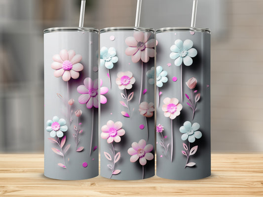 Three tumblers with pastel pink and blue floral designs and straws.