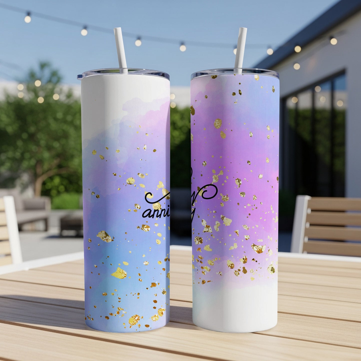Two tall tumblers with watercolor and gold confetti designs on a table.