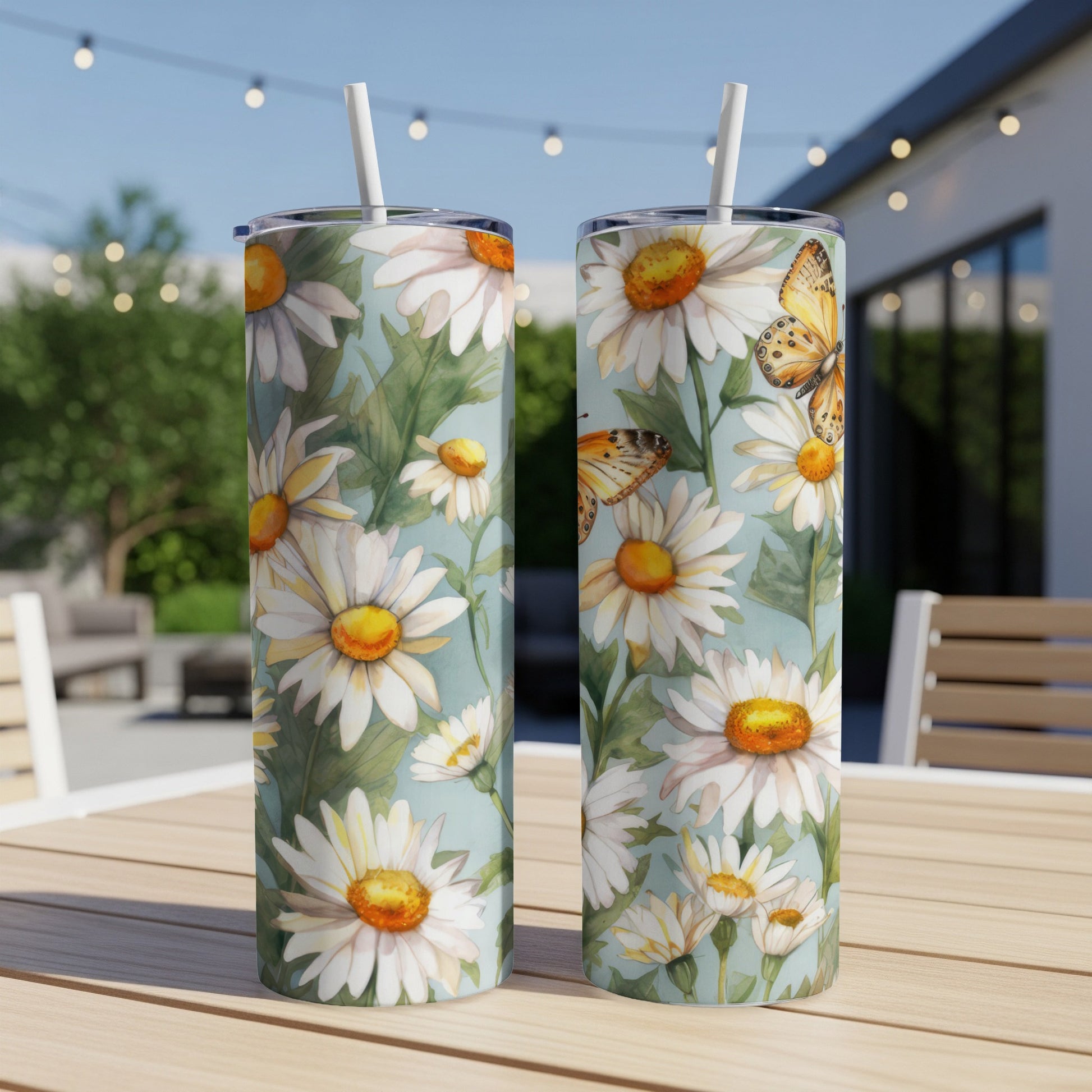 Two tumblers with white daisies and orange butterflies on a light blue background.