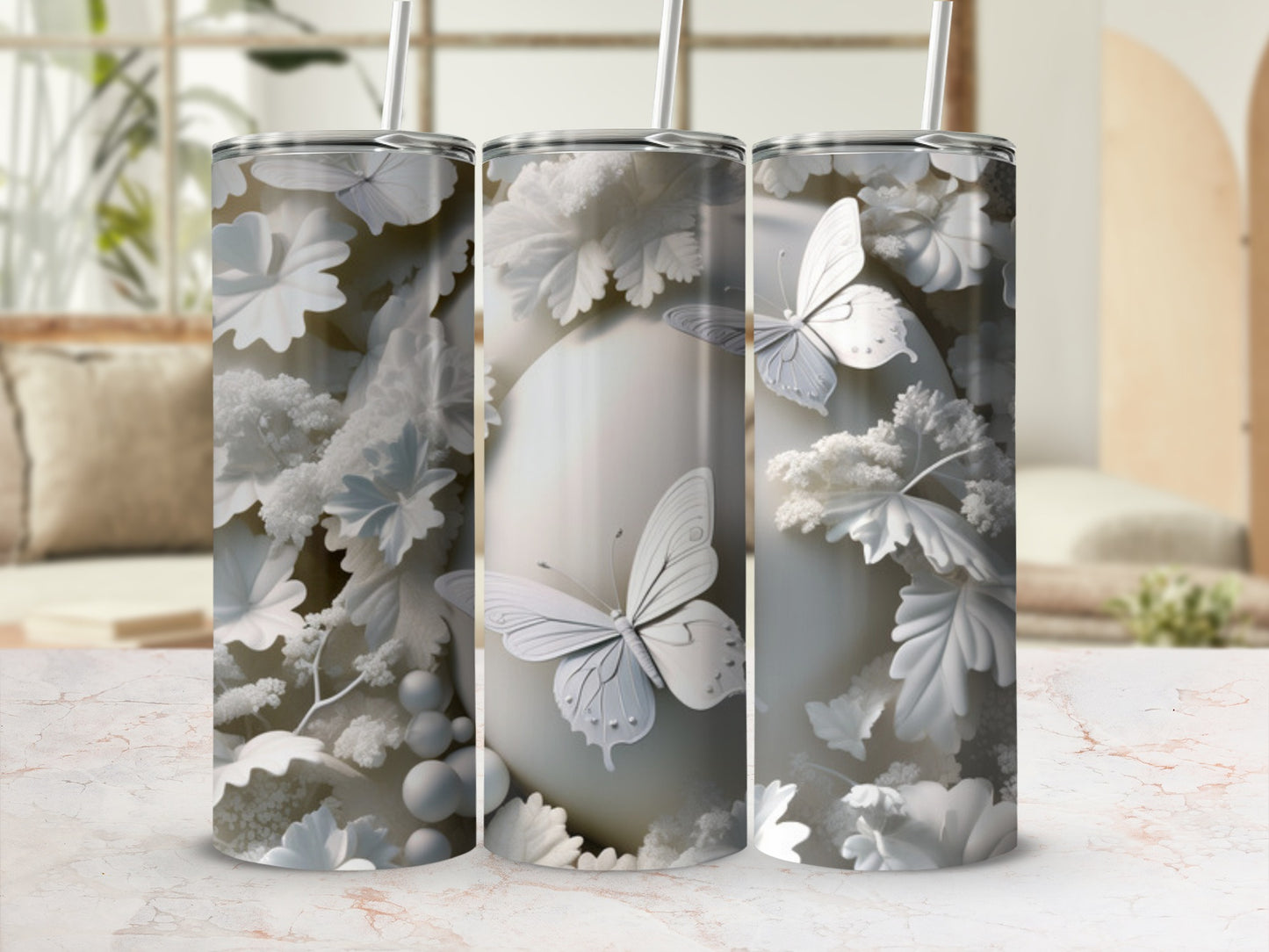 White floral and butterfly pattern on three tall tumblers with straws.