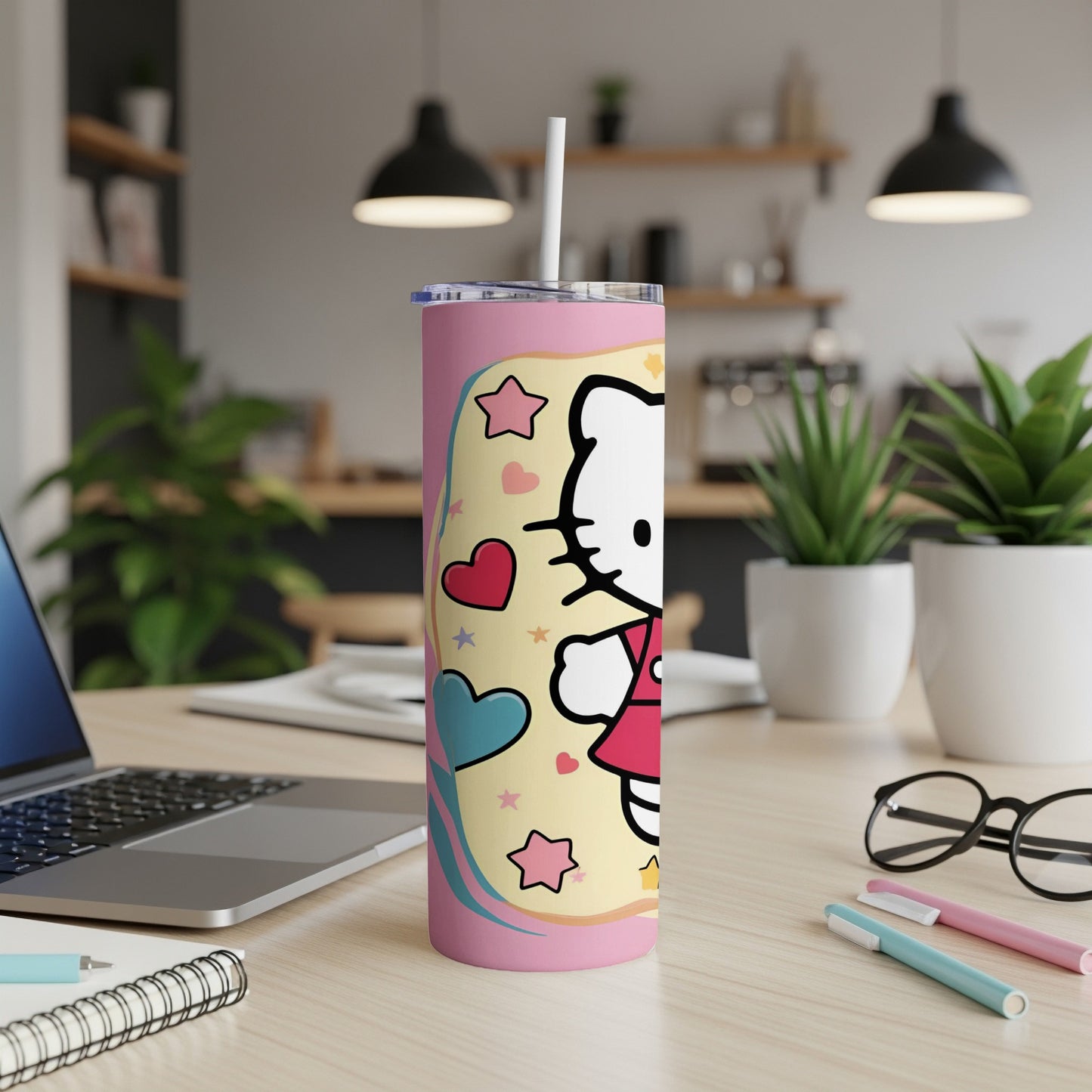 Pink tumbler with Hello Kitty and hearts on a desk.