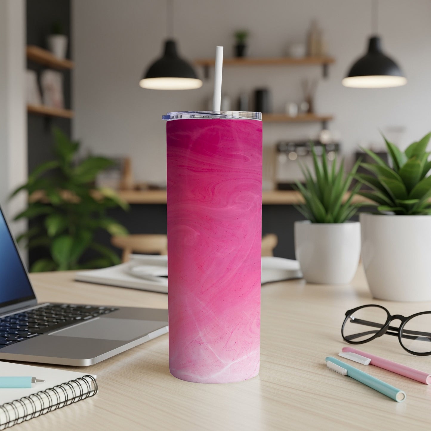 Pink gradient tumbler with white straw on a desk.