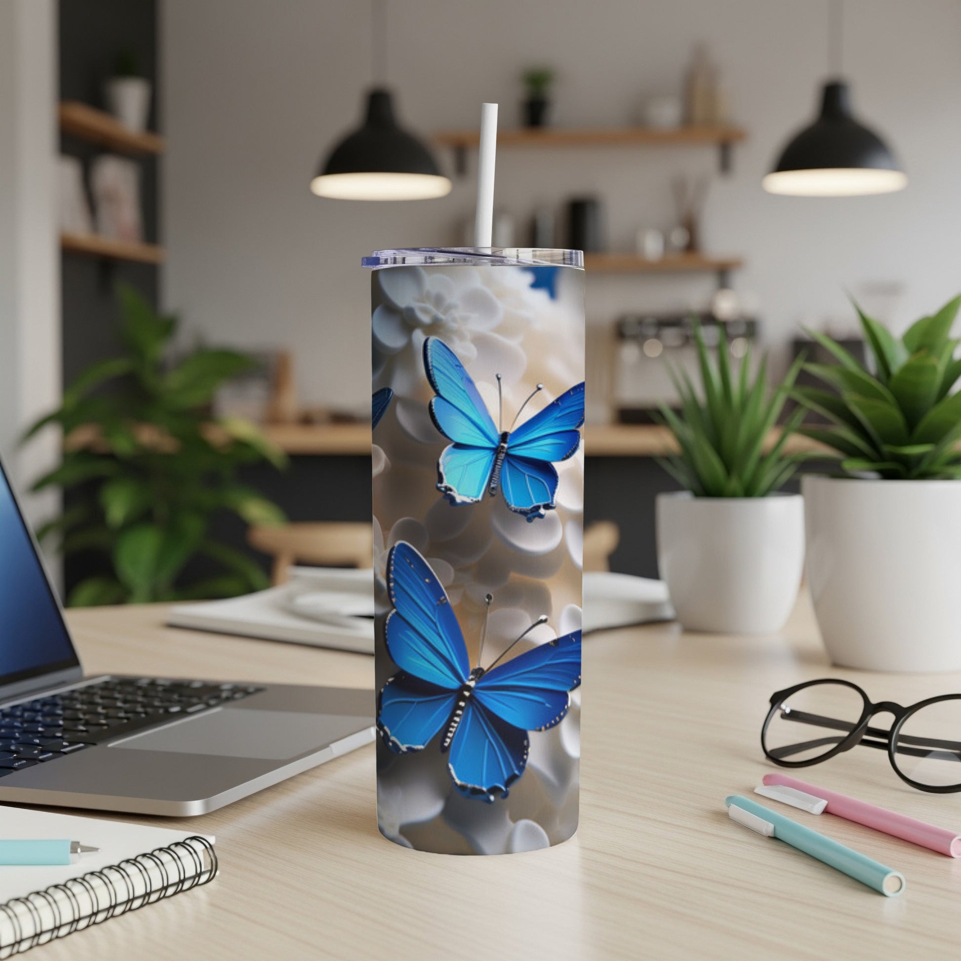 Blue butterflies on a white speckled background adorn a white tumbler with straw.