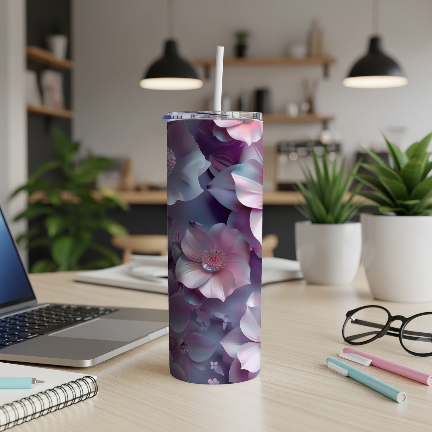 Tumbler with purple and pink floral design on a desk.