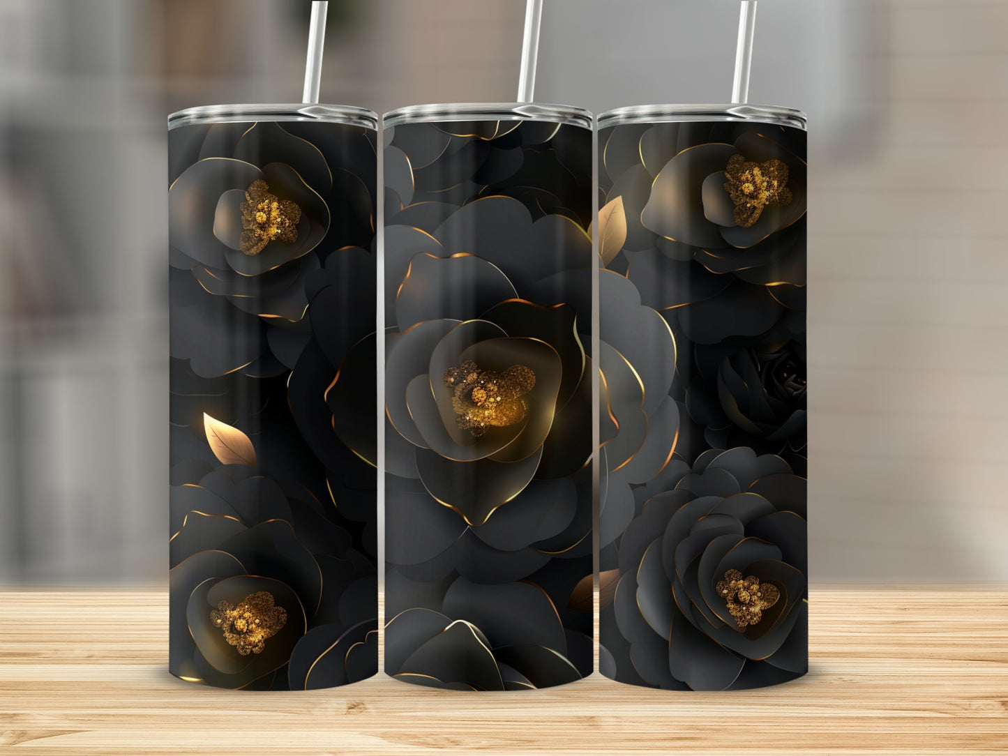 Three black tumblers with golden floral accents displayed on a wooden surface.