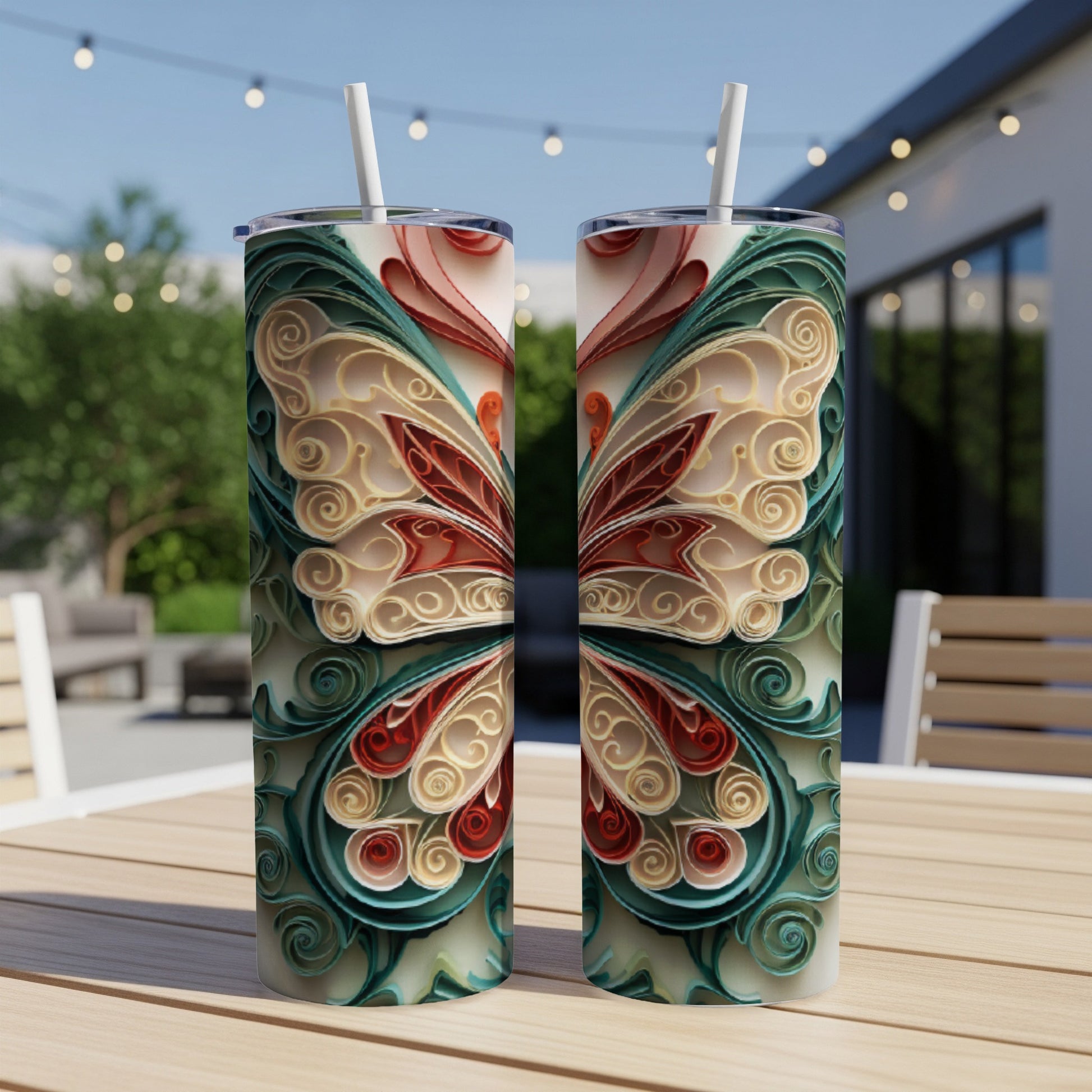 Two identical tumblers with symmetrical red and teal butterfly wing quilled paper designs.