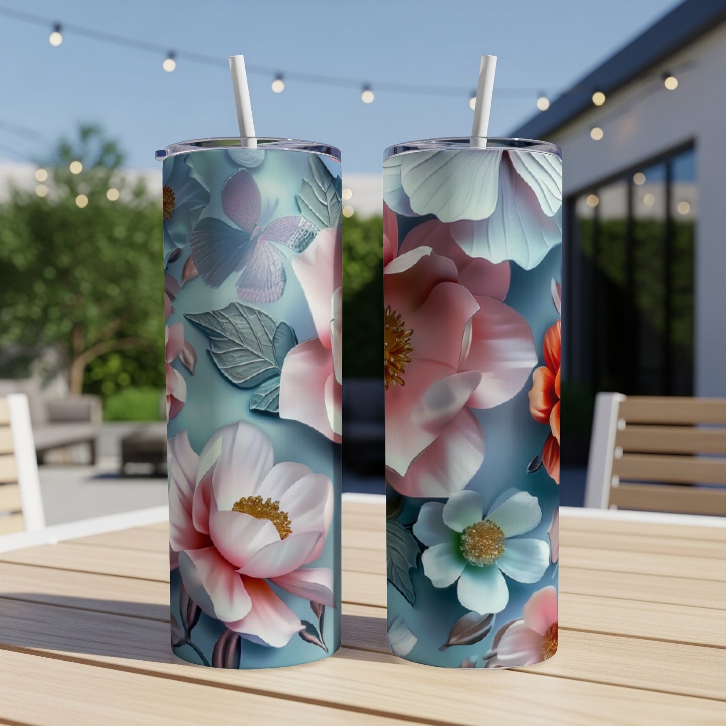 Two floral tumblers with pink and blue flowers and leaves on a table.