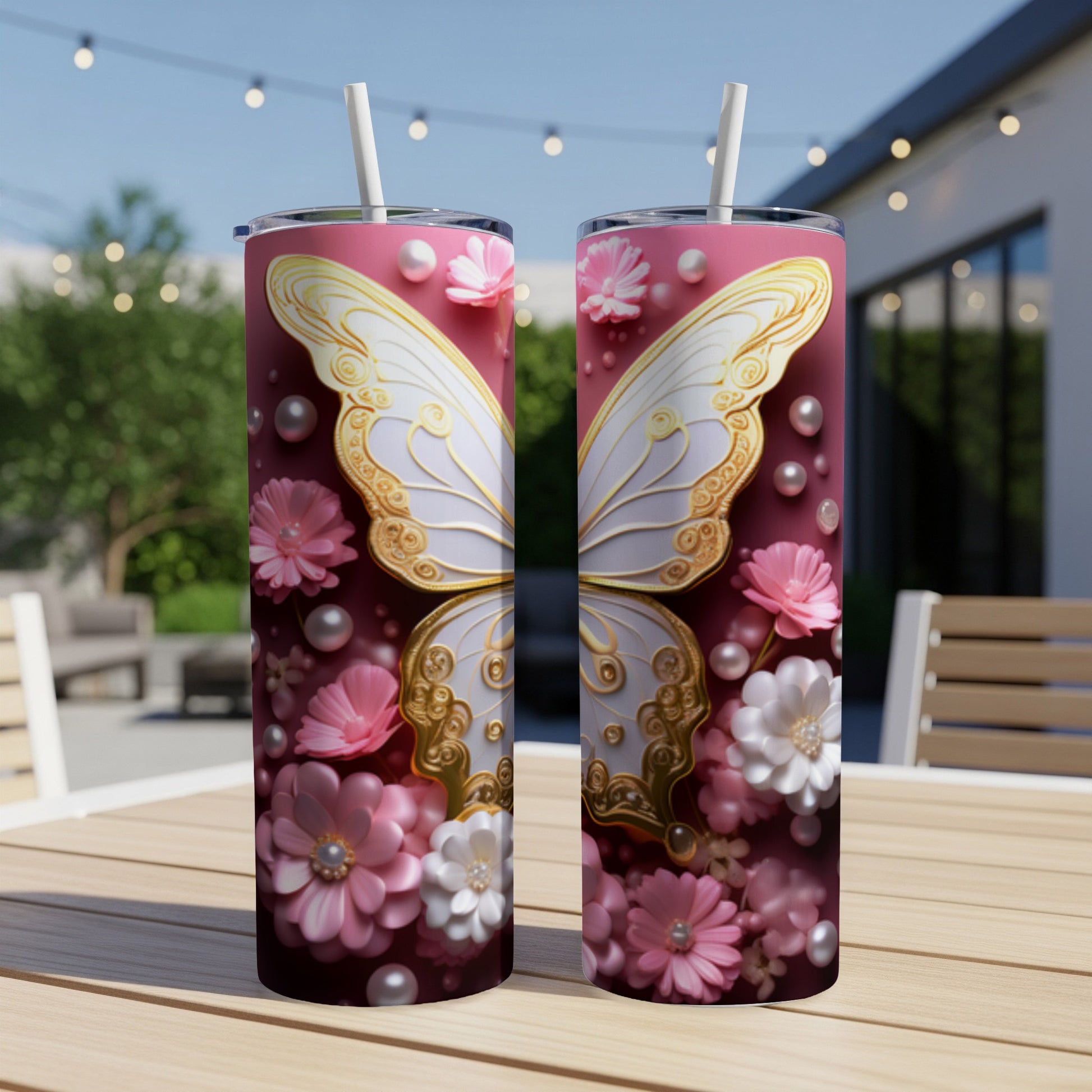 Two pink tumblers with white butterfly and floral designs sit on a table.