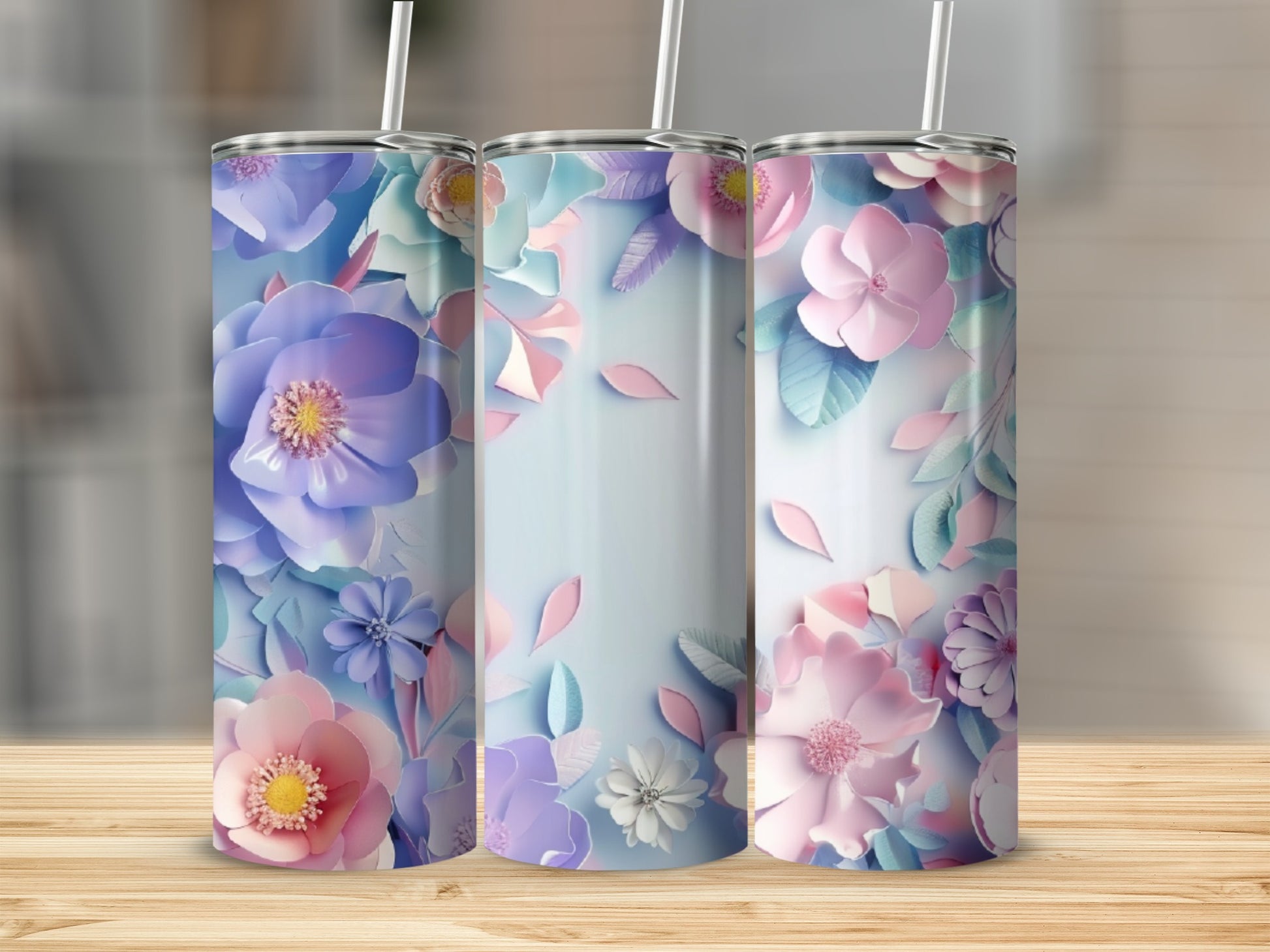 Three tall tumblers with pastel floral designs on a wooden surface.