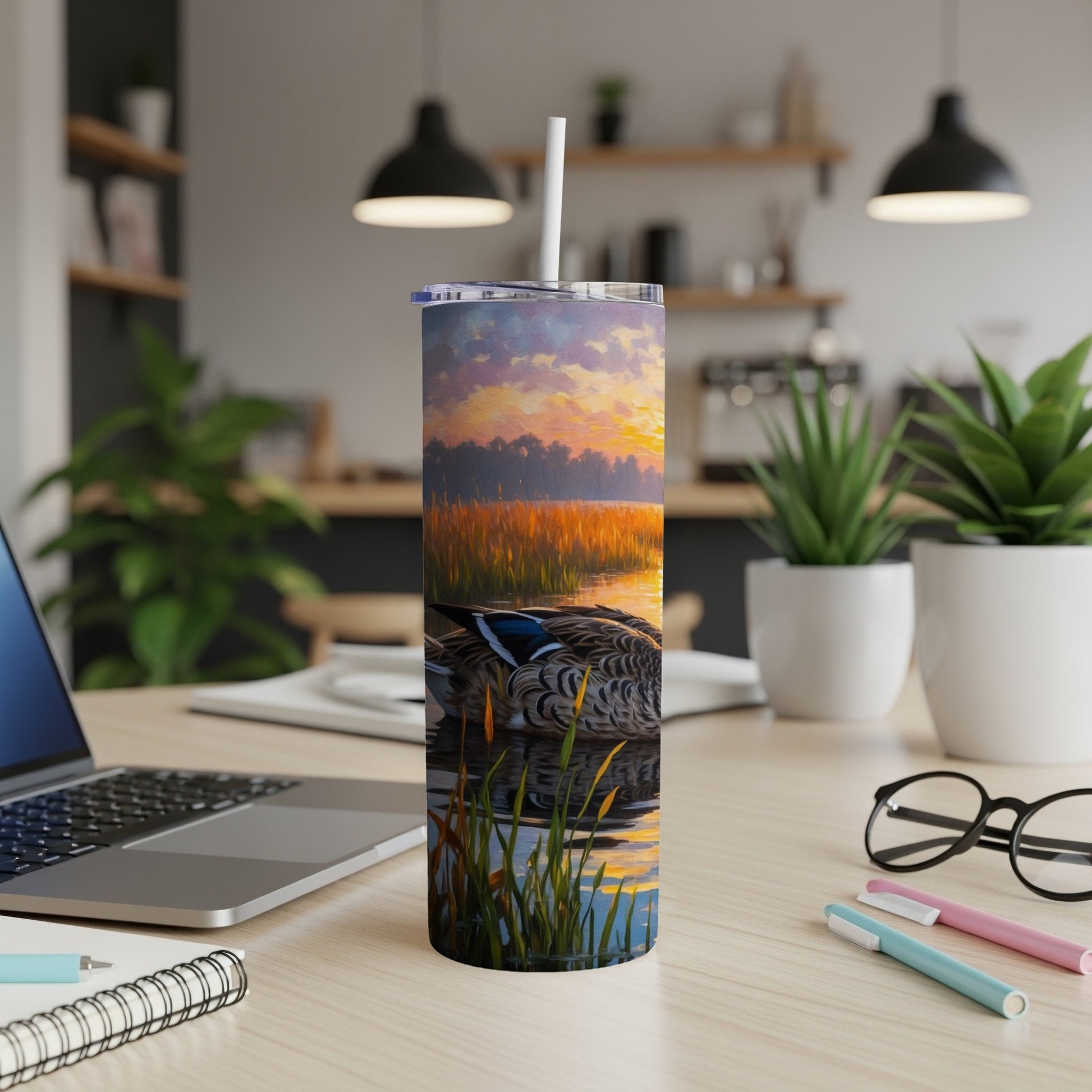 Duck on water at sunrise, depicted on a skinny tumbler with a straw.