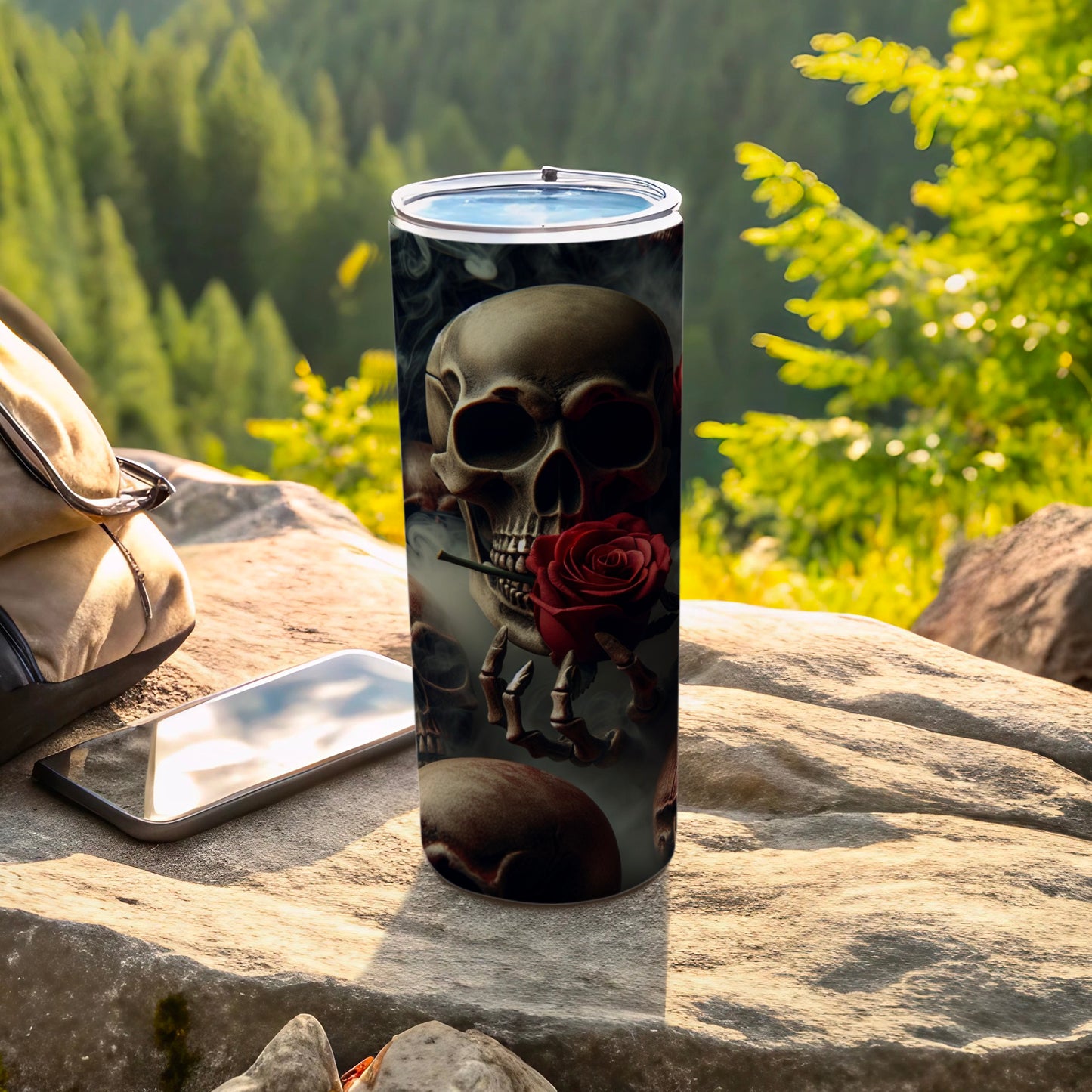 Tumbler with skull and rose design, set outdoors.