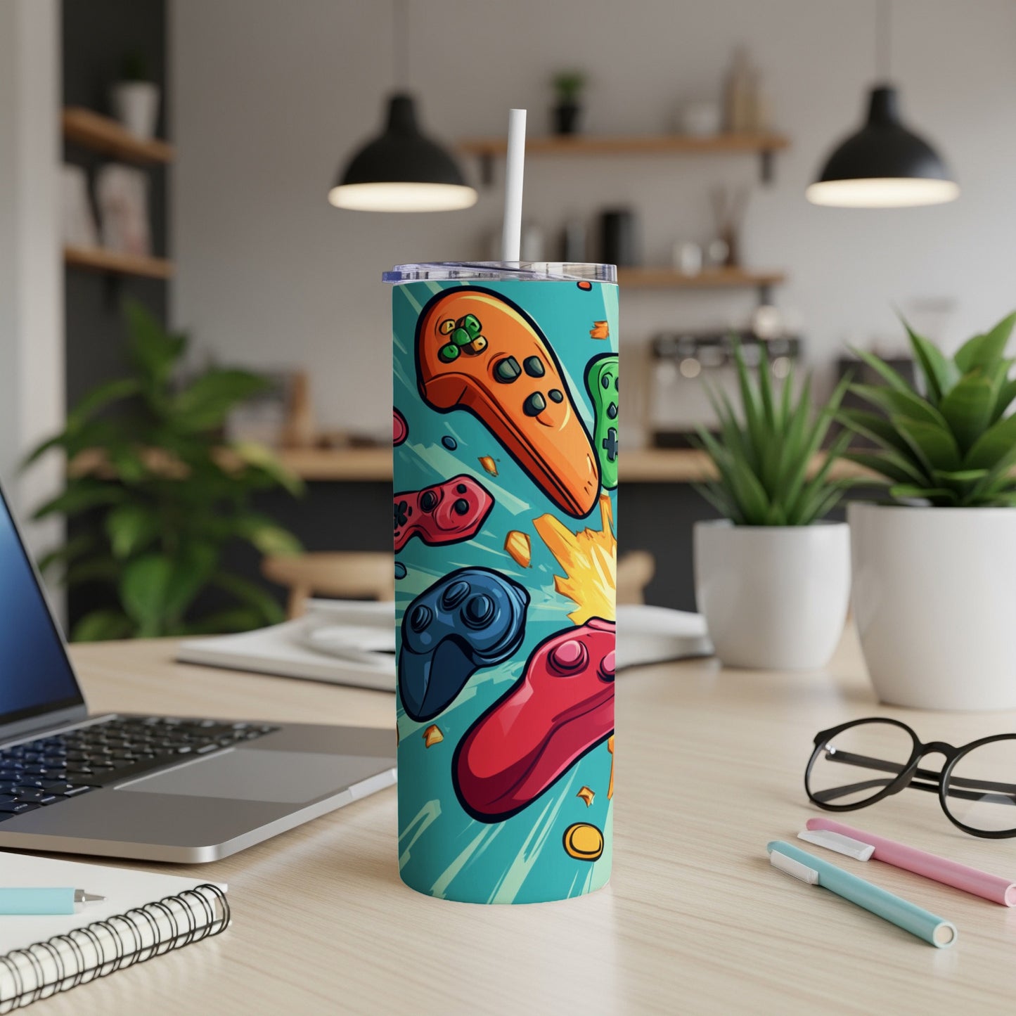 Teal tumbler with colorful video game controllers and explosions.