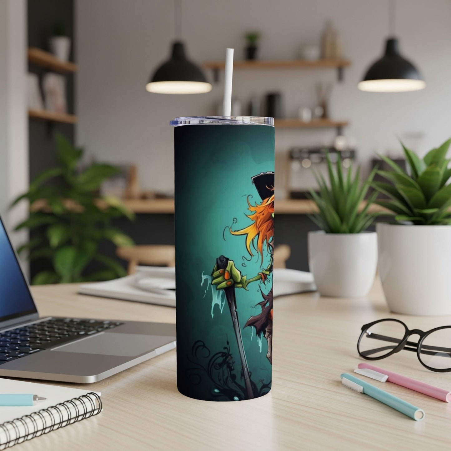 Tumbler with a cartoon scarecrow design on a teal background.