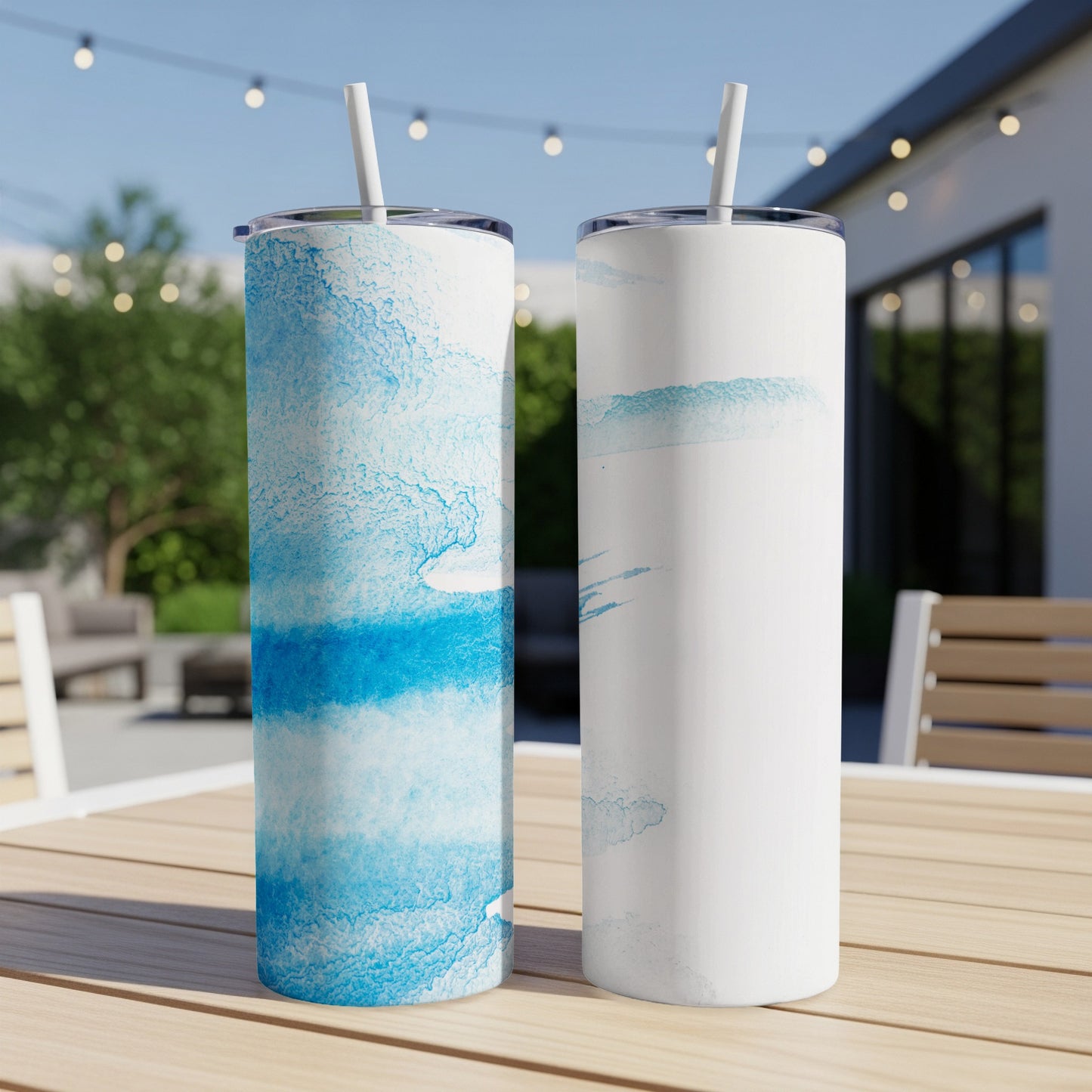 Two tall tumblers with blue watercolor patterns on a wooden table.