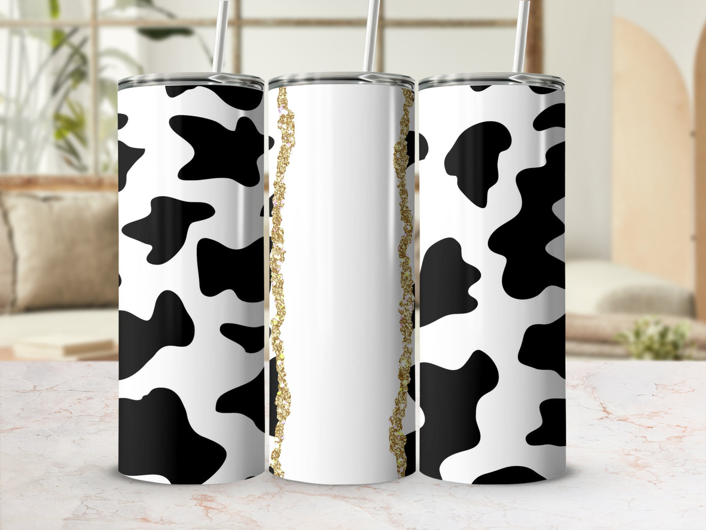 Cow print tumbler with gold glitter accent strip.