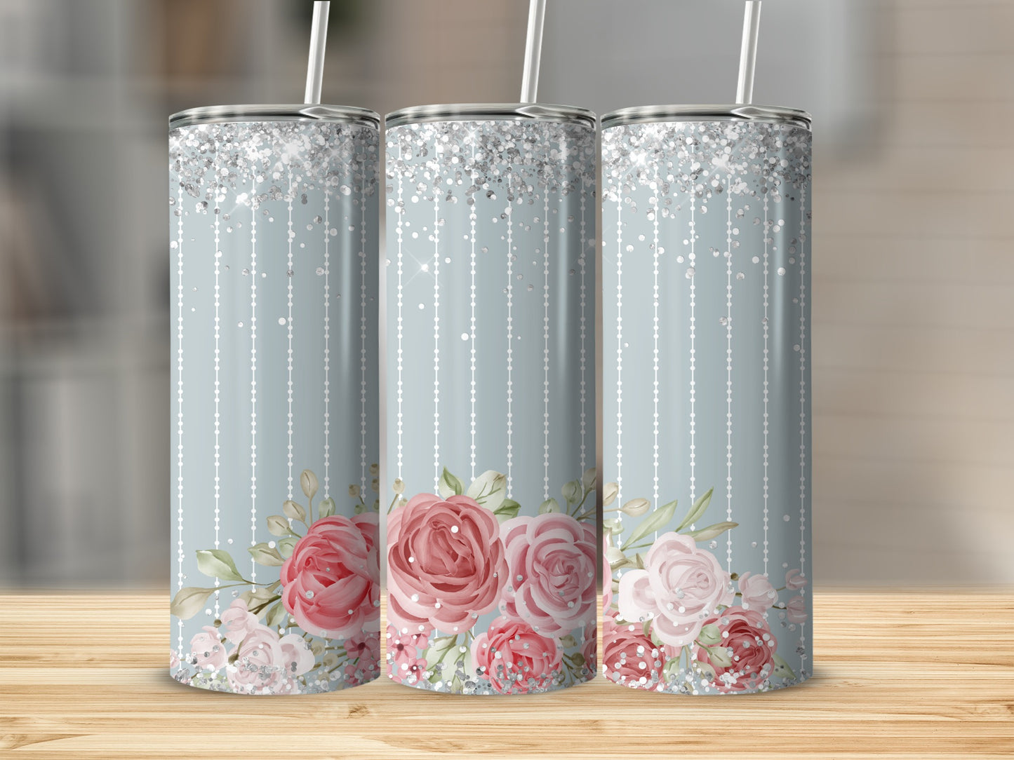 Three pastel tumblers with floral accents and glitter accents.