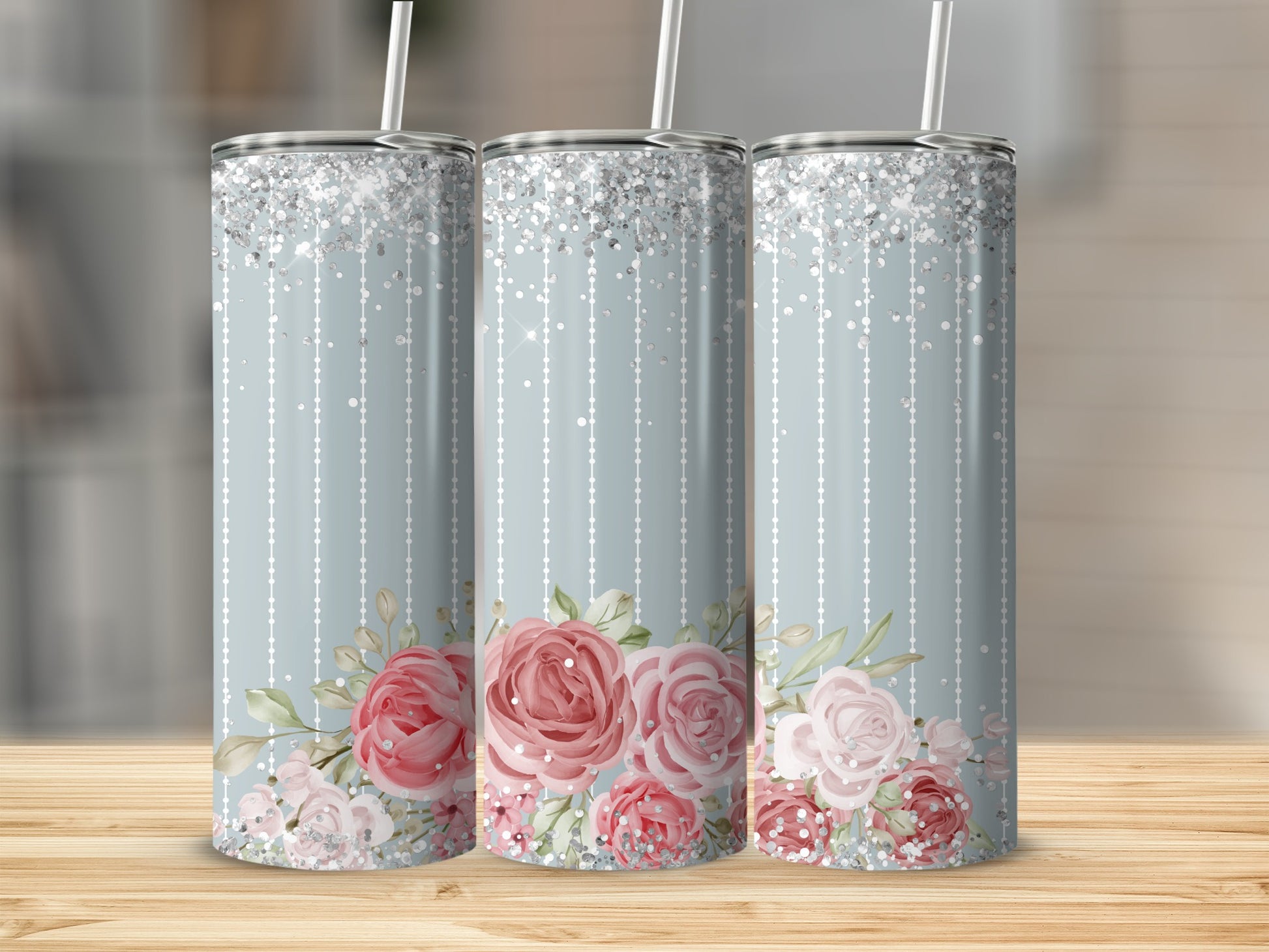 Three pastel tumblers with floral accents and glitter accents.