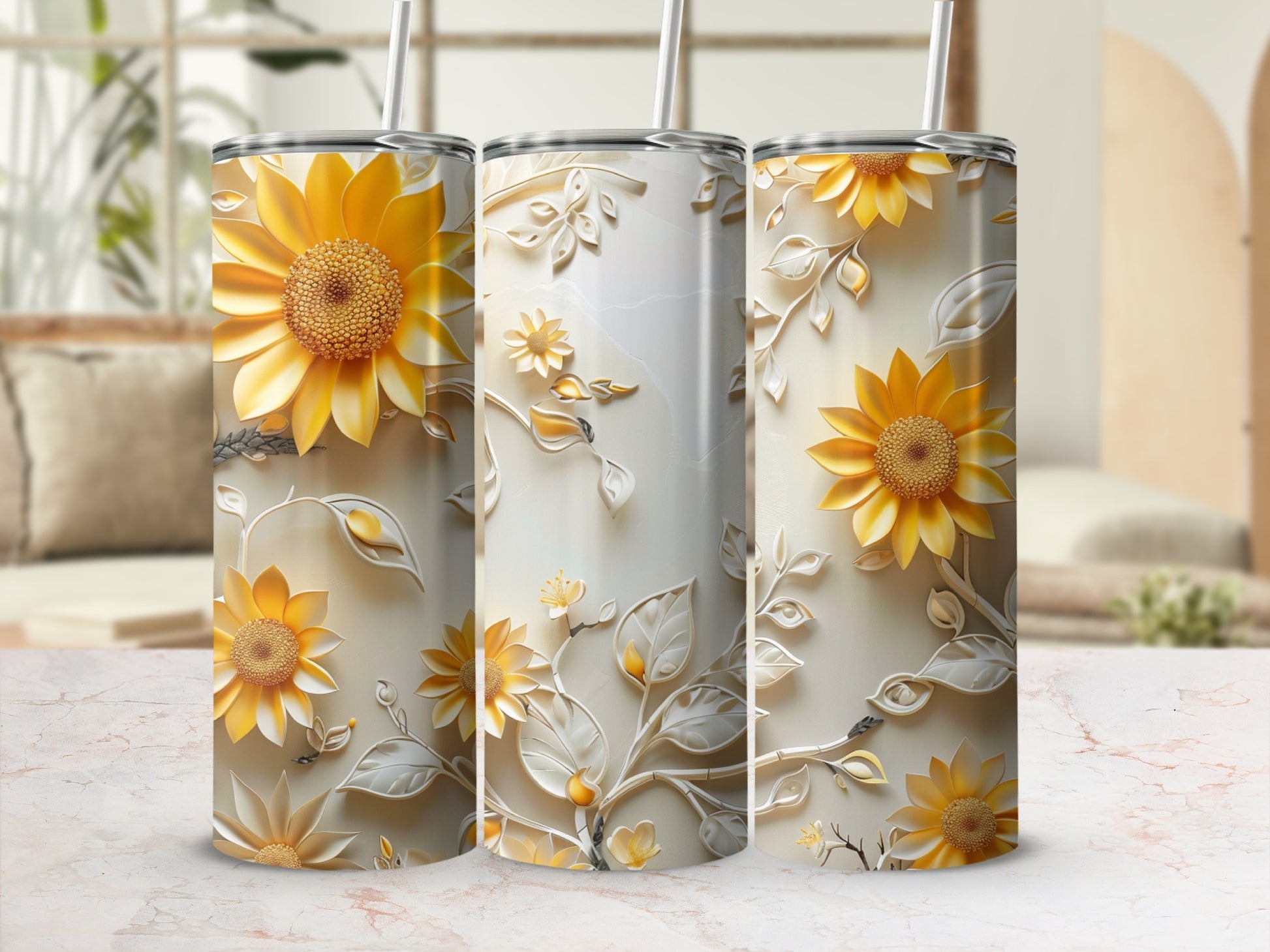 Three sunflower tumblers with floral embossed designs on a marble surface.