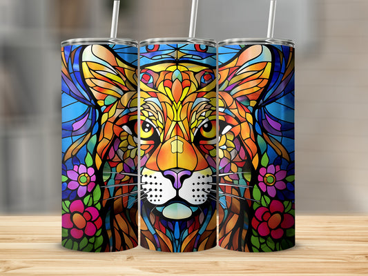 Stained glass lion face with colorful flowers on a patterned tumbler.