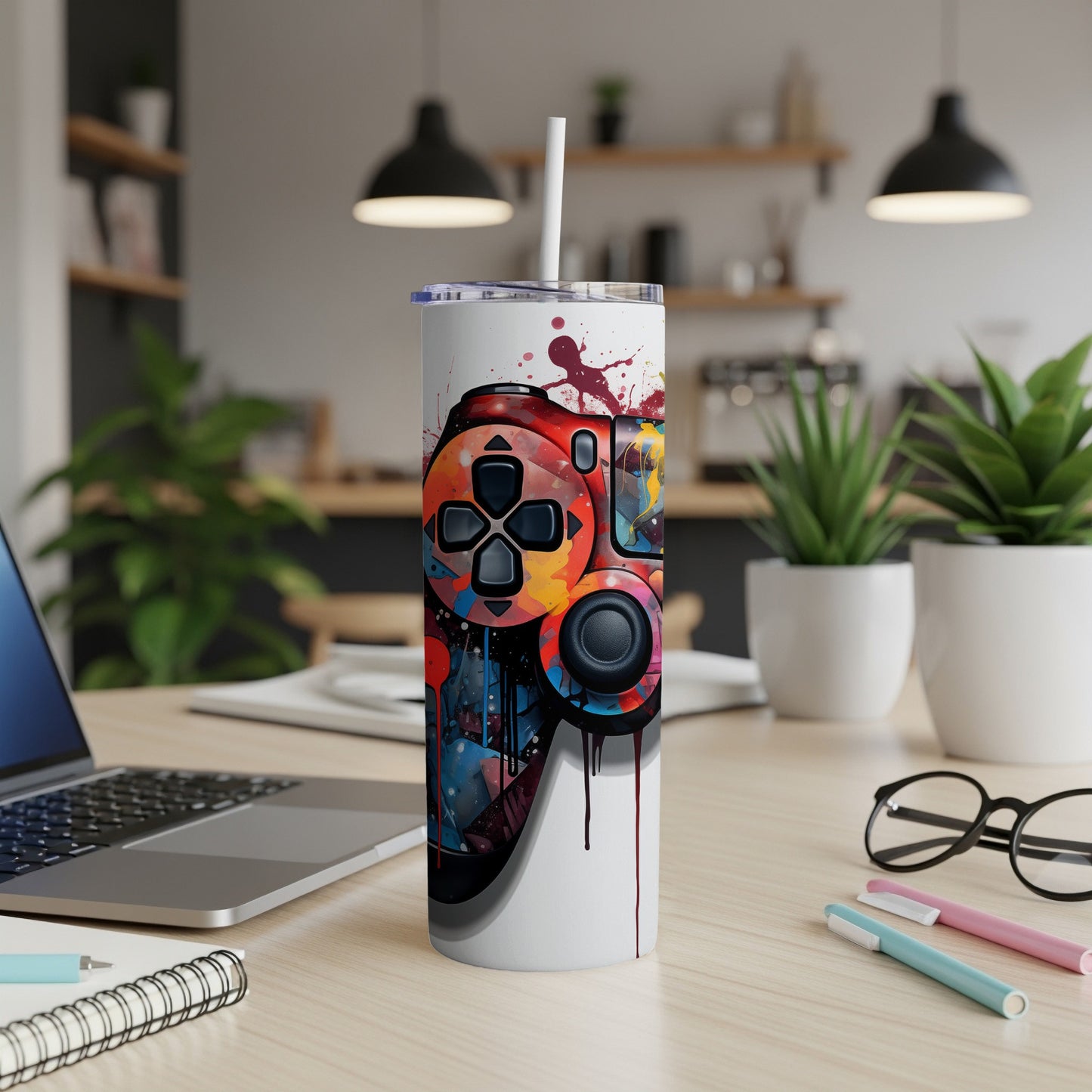 Colorful video game controller illustration on a white insulated tumbler with straw.