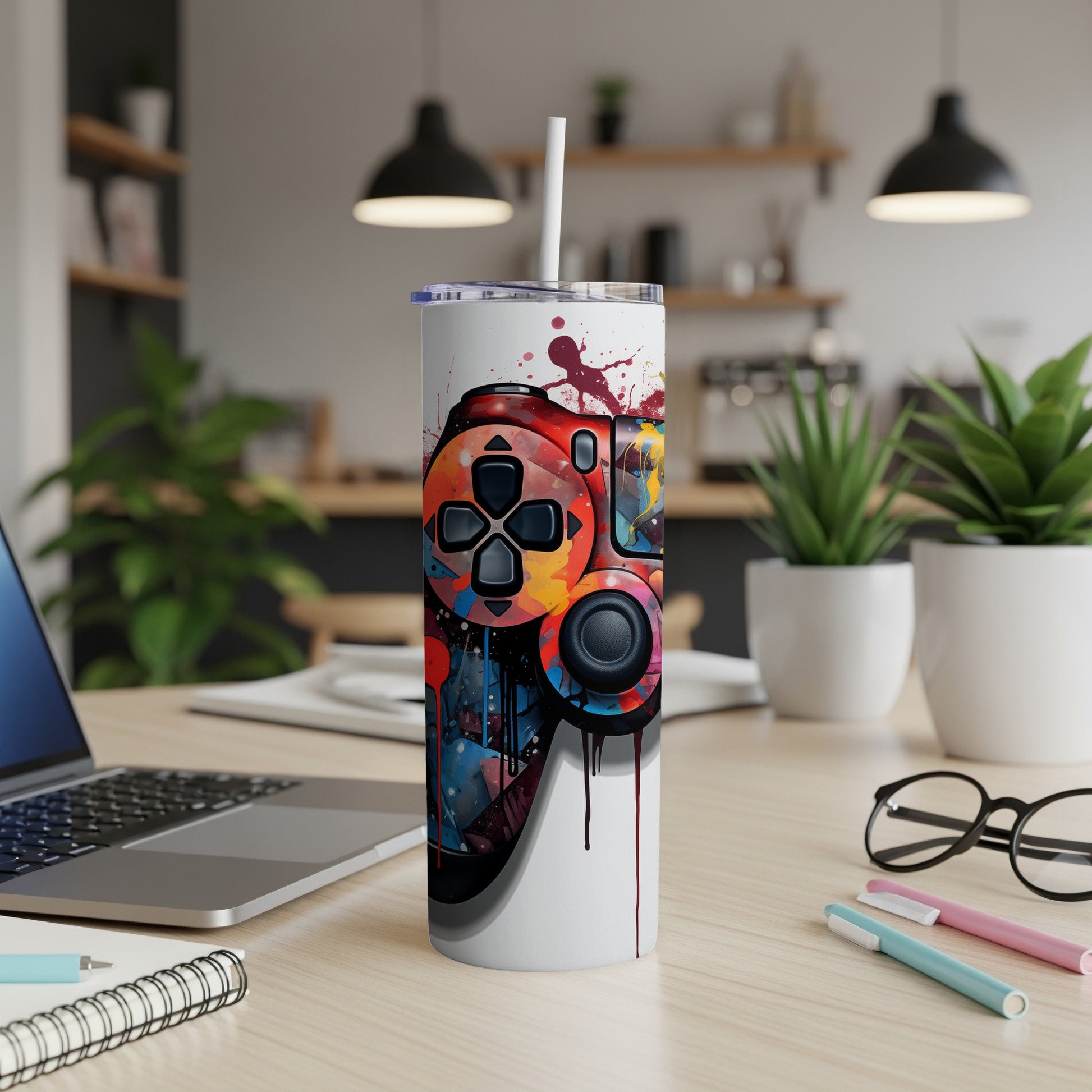 Colorful video game controller illustration on a white insulated tumbler with straw.