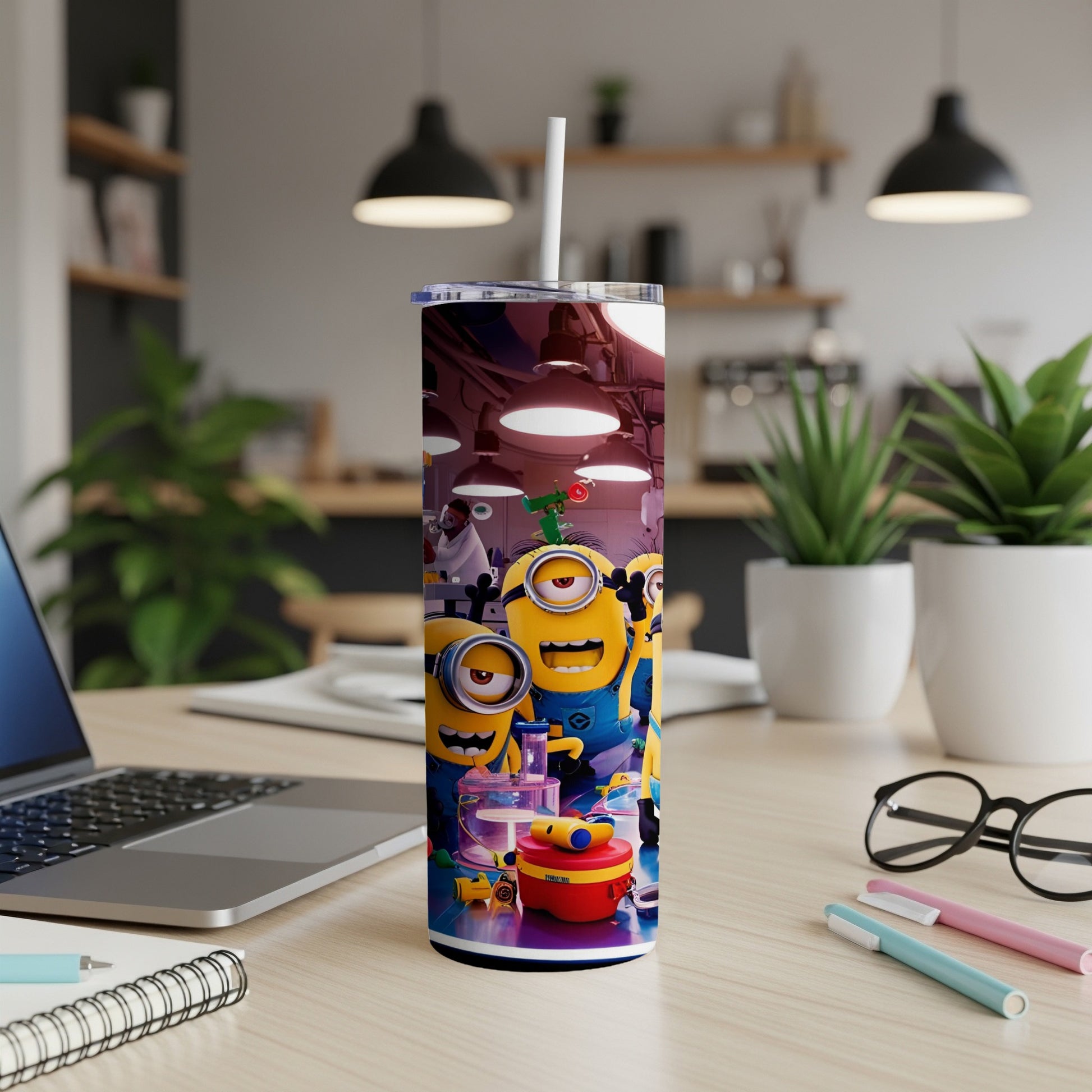 Minions characters on a tumbler with a straw, placed on a wooden desk.