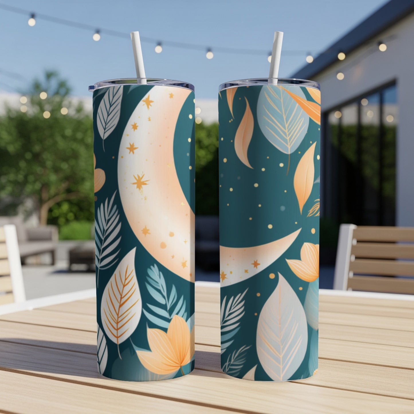 Two tumblers with celestial moon and leaf design on a wooden table.