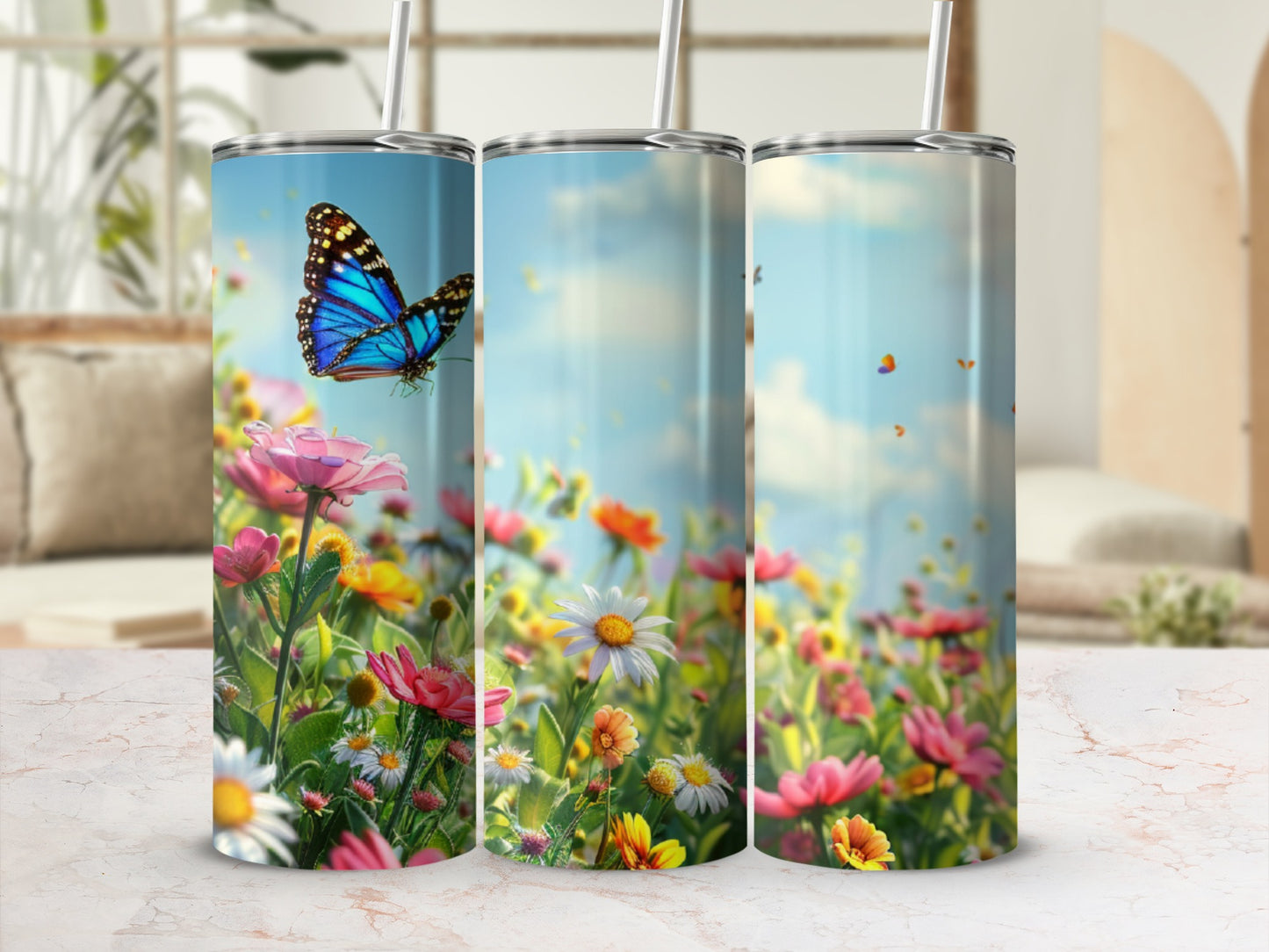 Three tumblers feature a vibrant butterfly flying over a field of colorful flowers.