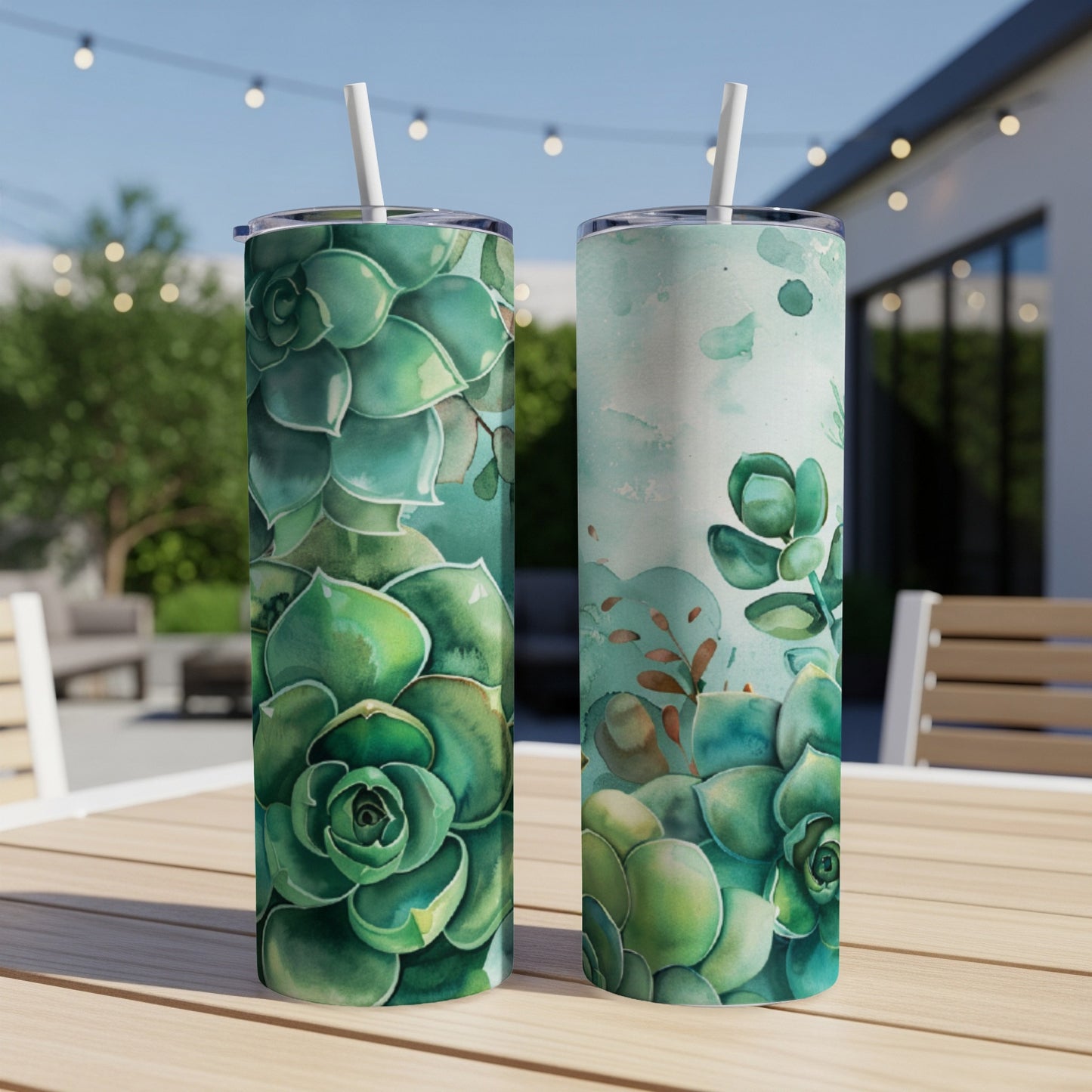 Two green succulent tumblers with straws on a wooden table.