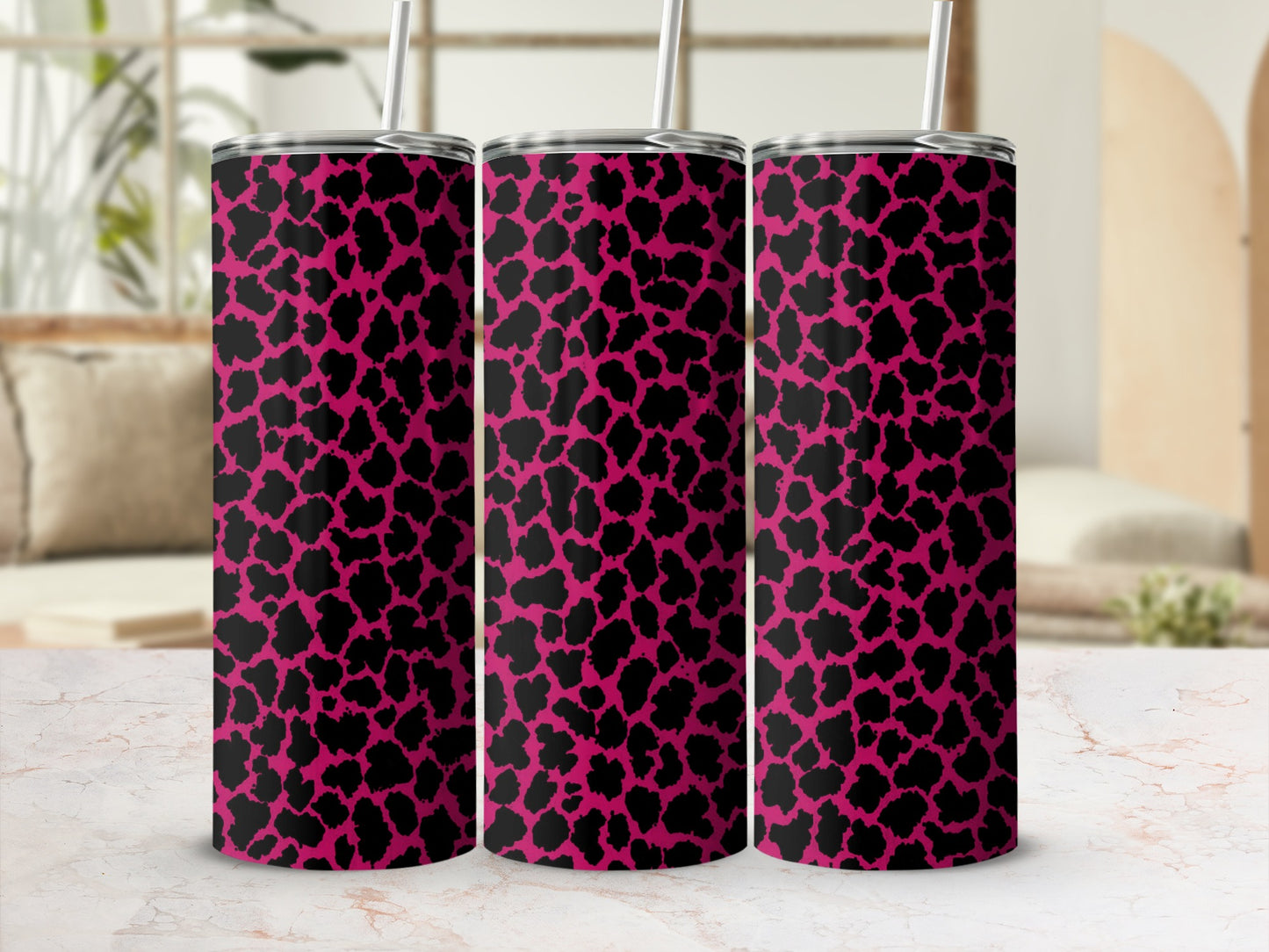 Three tumblers with pink and black leopard print pattern and straws.