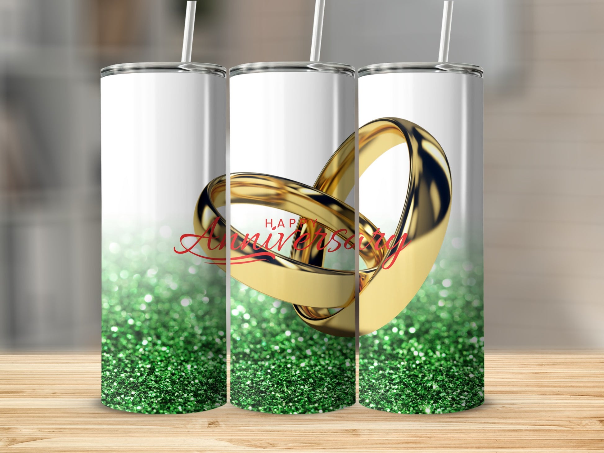 Two gold wedding rings with "Happy Anniversary" text and green glitter.