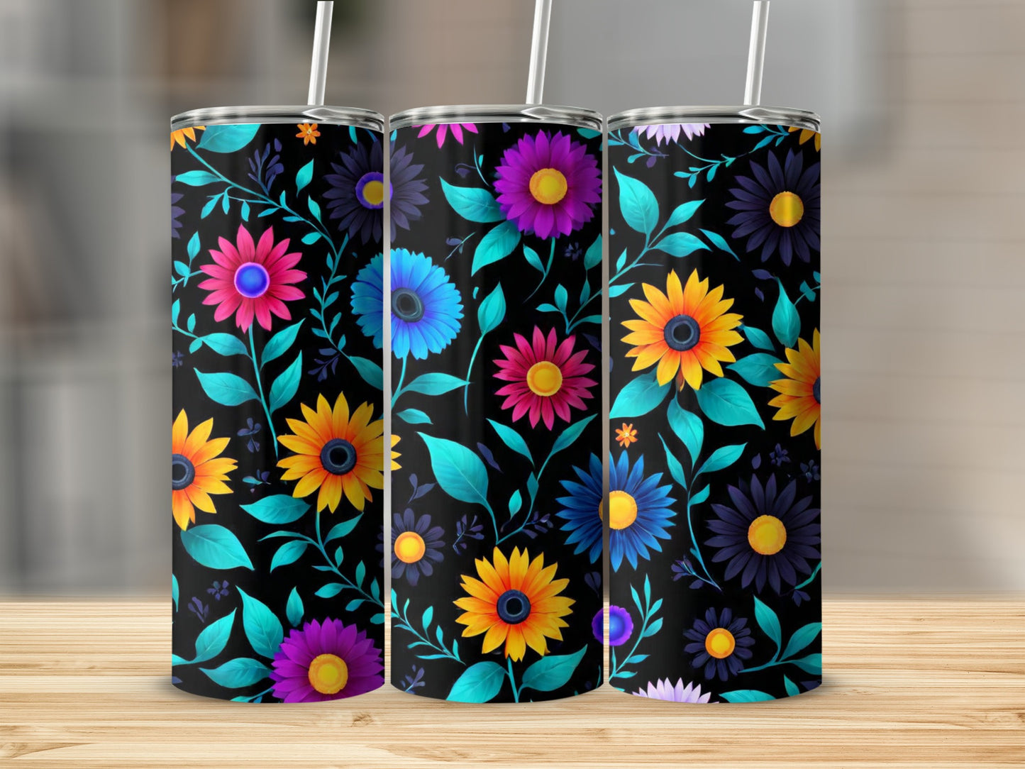 Three tumblers with a vibrant floral pattern on a wooden surface.