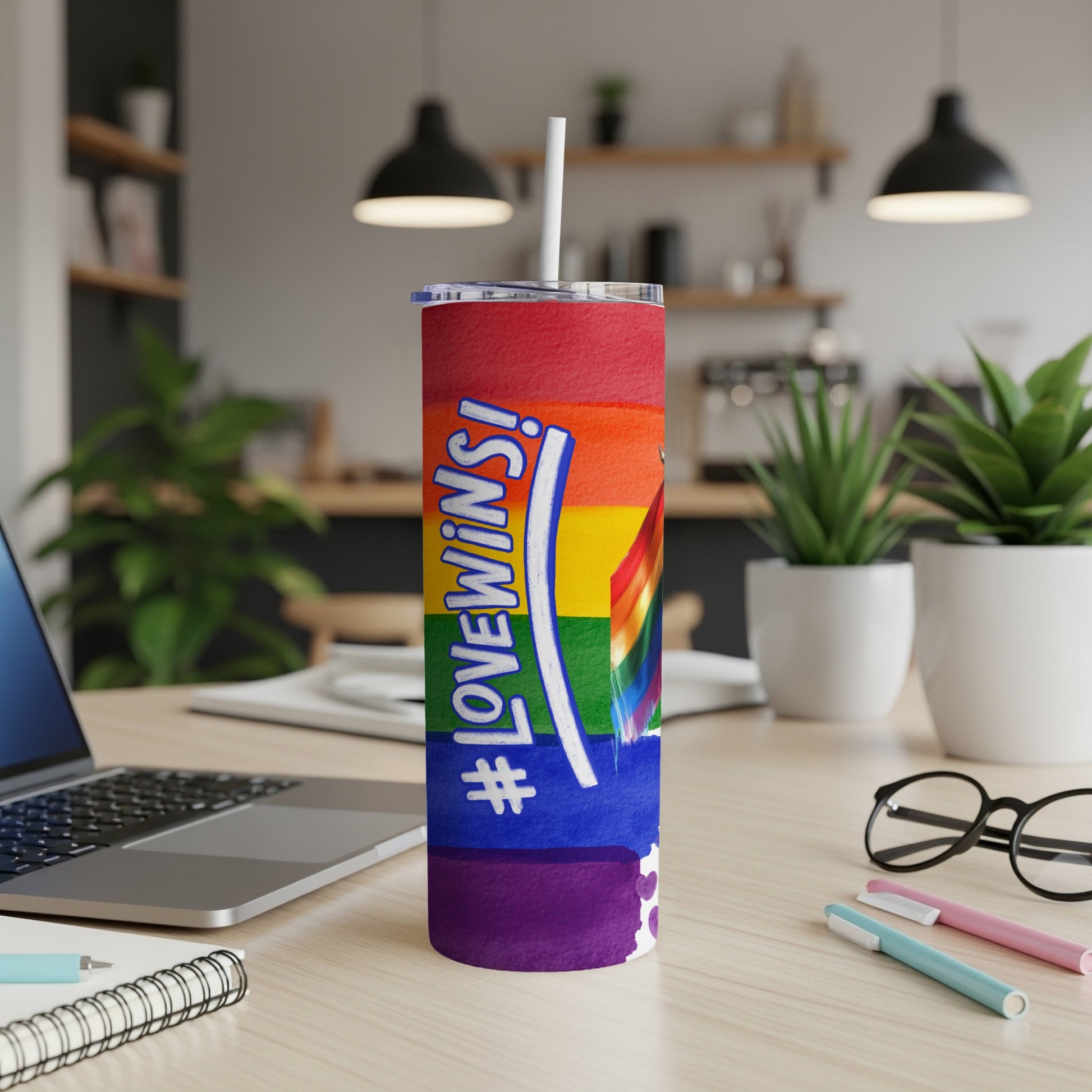 Rainbow Pride tumbler with "#LoveWins" and a white straw on a desk.