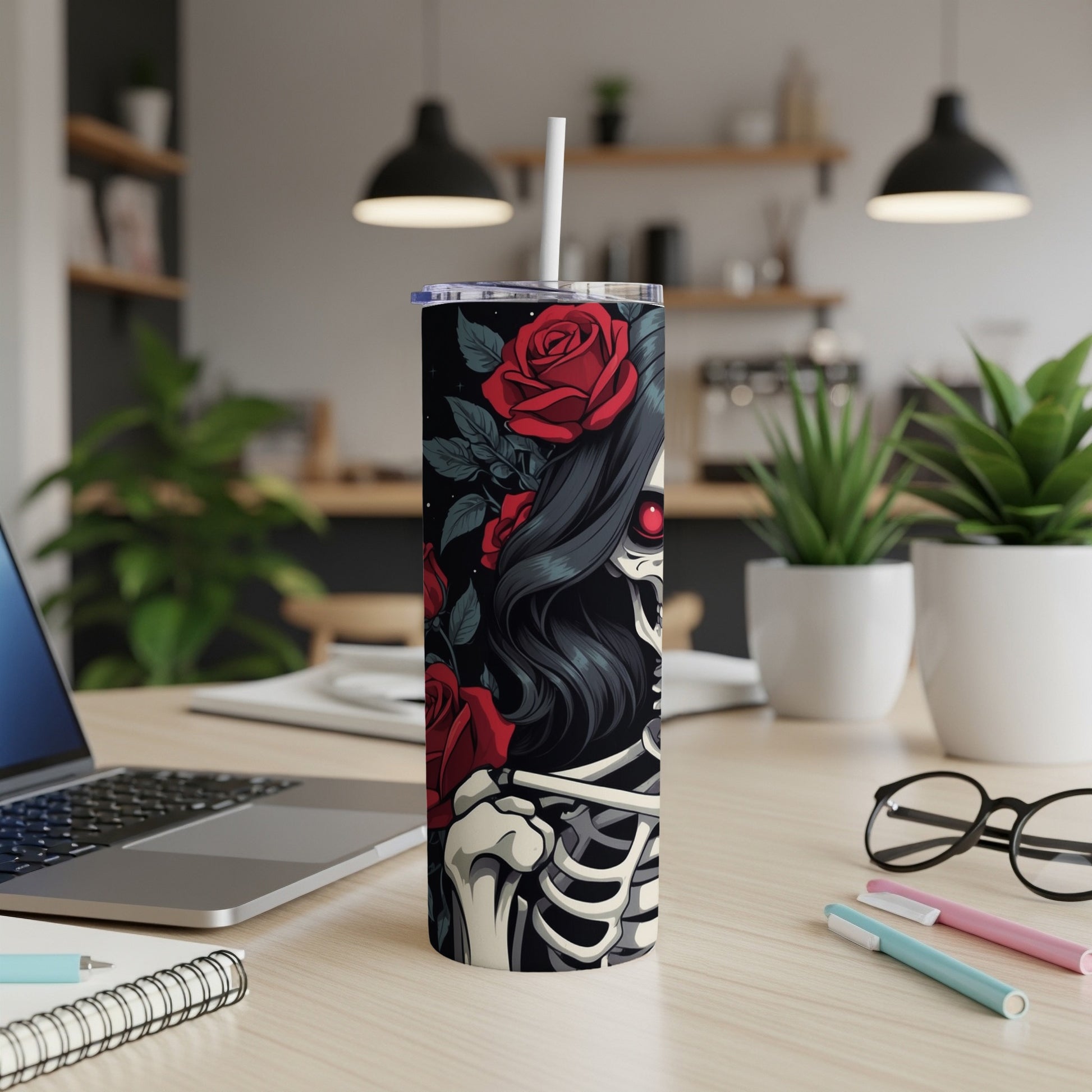 Tumbler with skull and roses design, laptop and desk accessories.