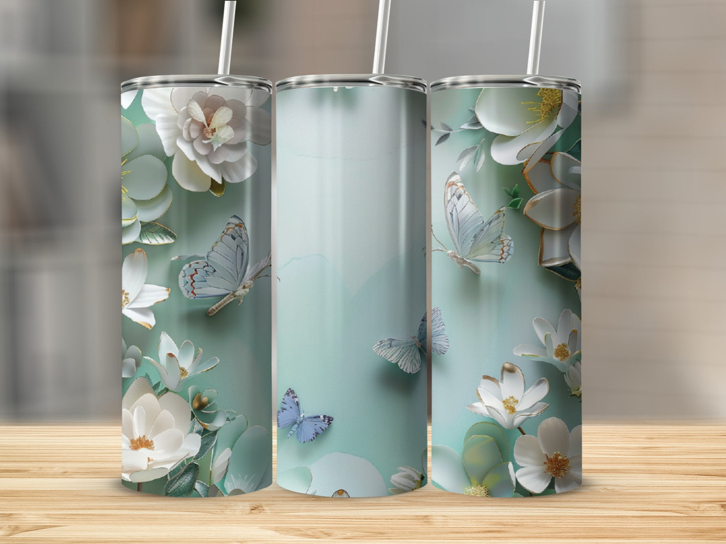 Floral and butterfly pattern on three tall tumblers with straws.