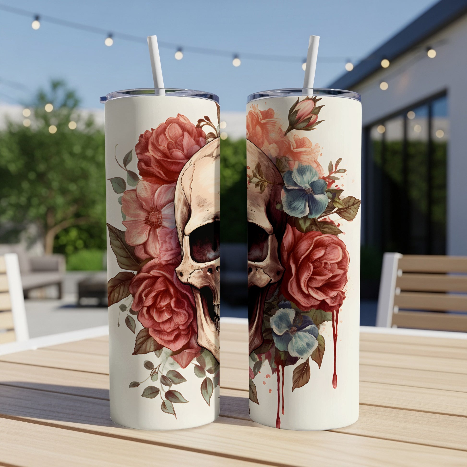 Two tumblers with a skull and floral design, sitting on a table.