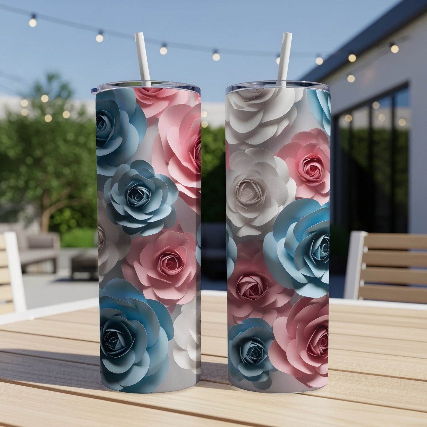 Two tumblers with pink, blue, and white paper flowers, on a wooden table.