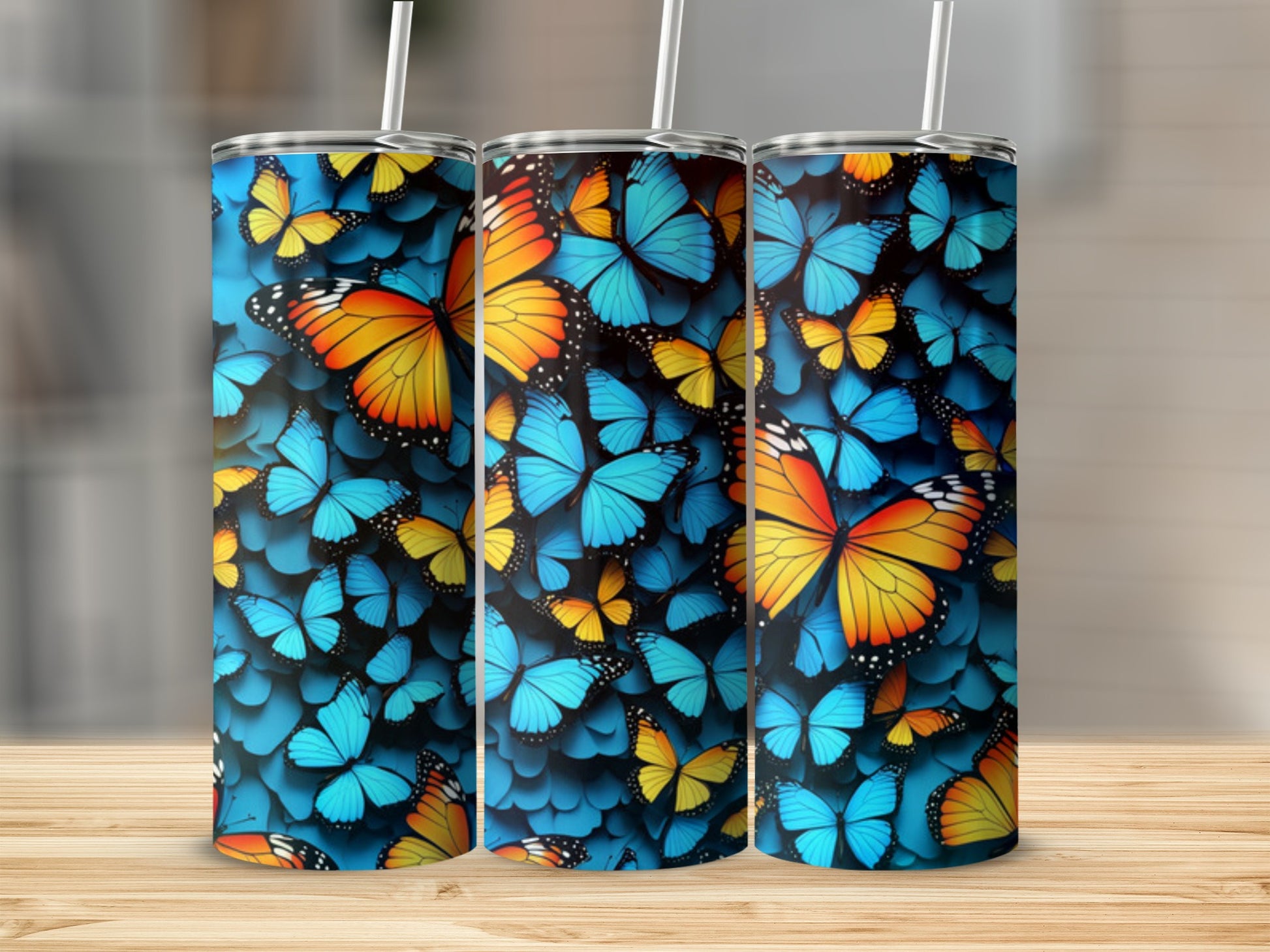 Three tumblers featuring a vibrant blue background with a repeating pattern of colorful butterflies.