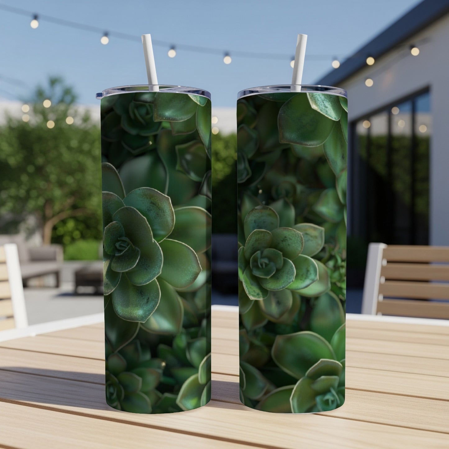 Two tumblers with a succulent plant pattern on a wooden table outdoors.