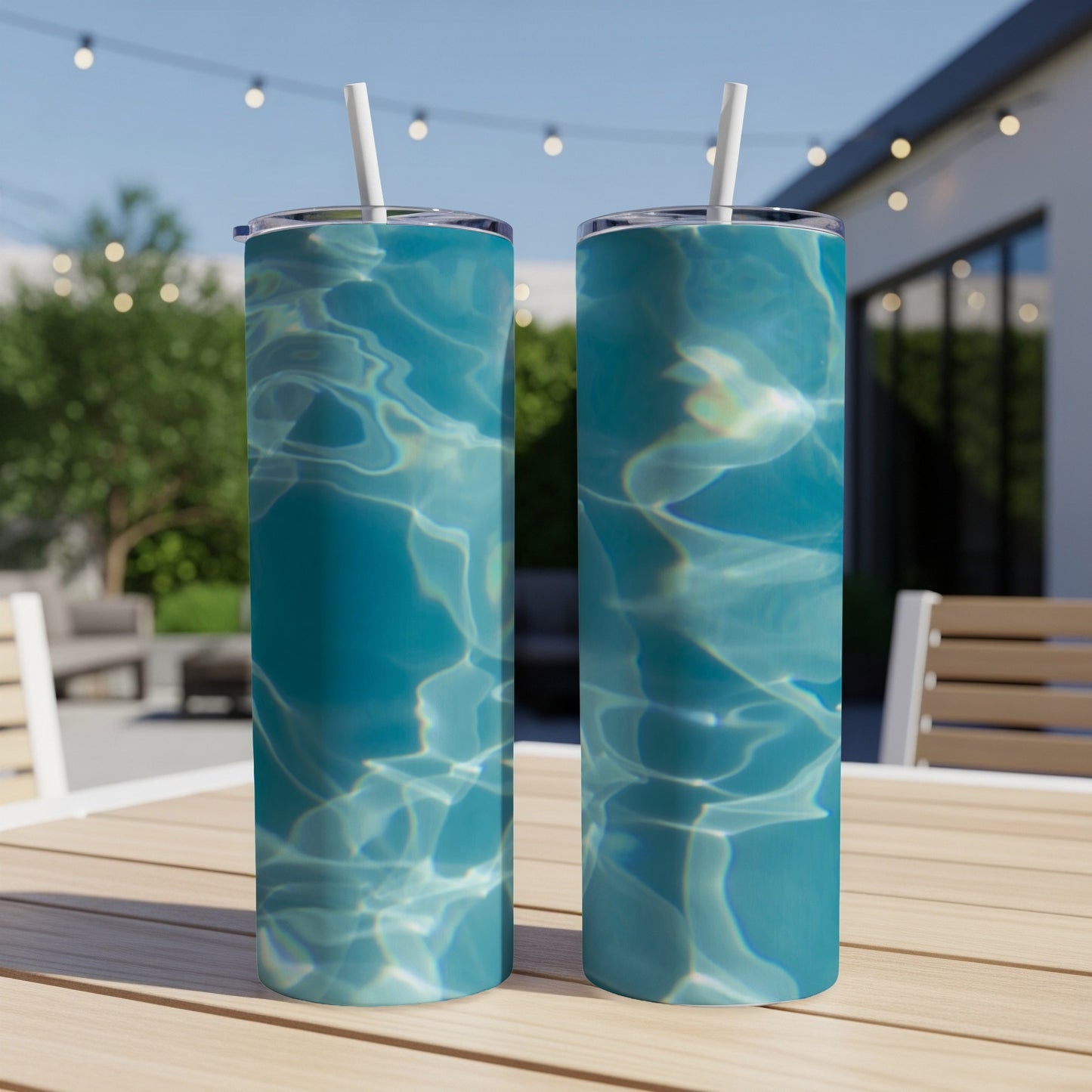 Two tumblers with a rippling blue water design sit on a wooden table.