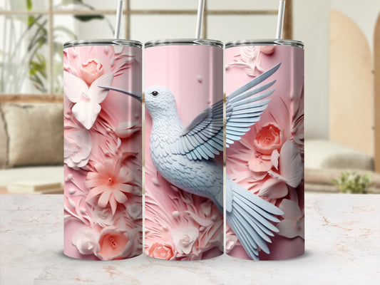 Pink tumbler with a white hummingbird and floral designs.