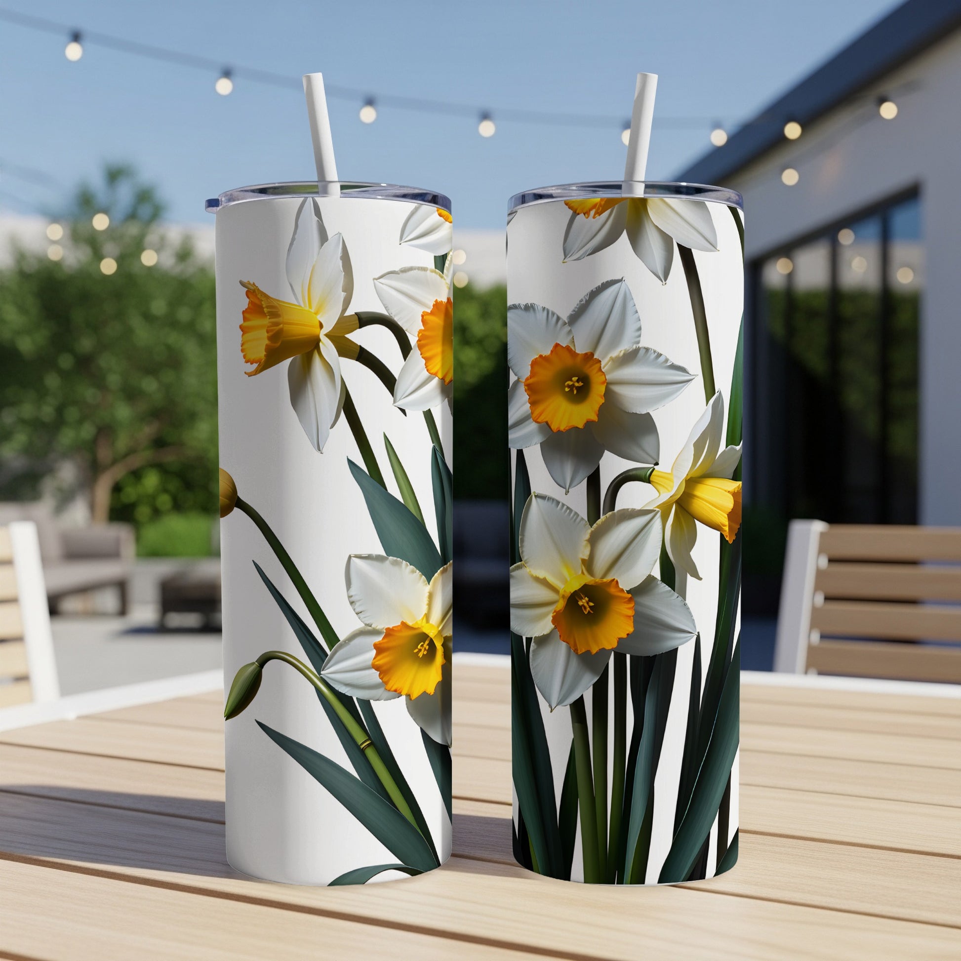 Two white tumblers with yellow and white daffodils and green leaves.