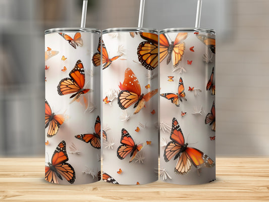 Three tumblers with orange and black monarch butterfly designs.