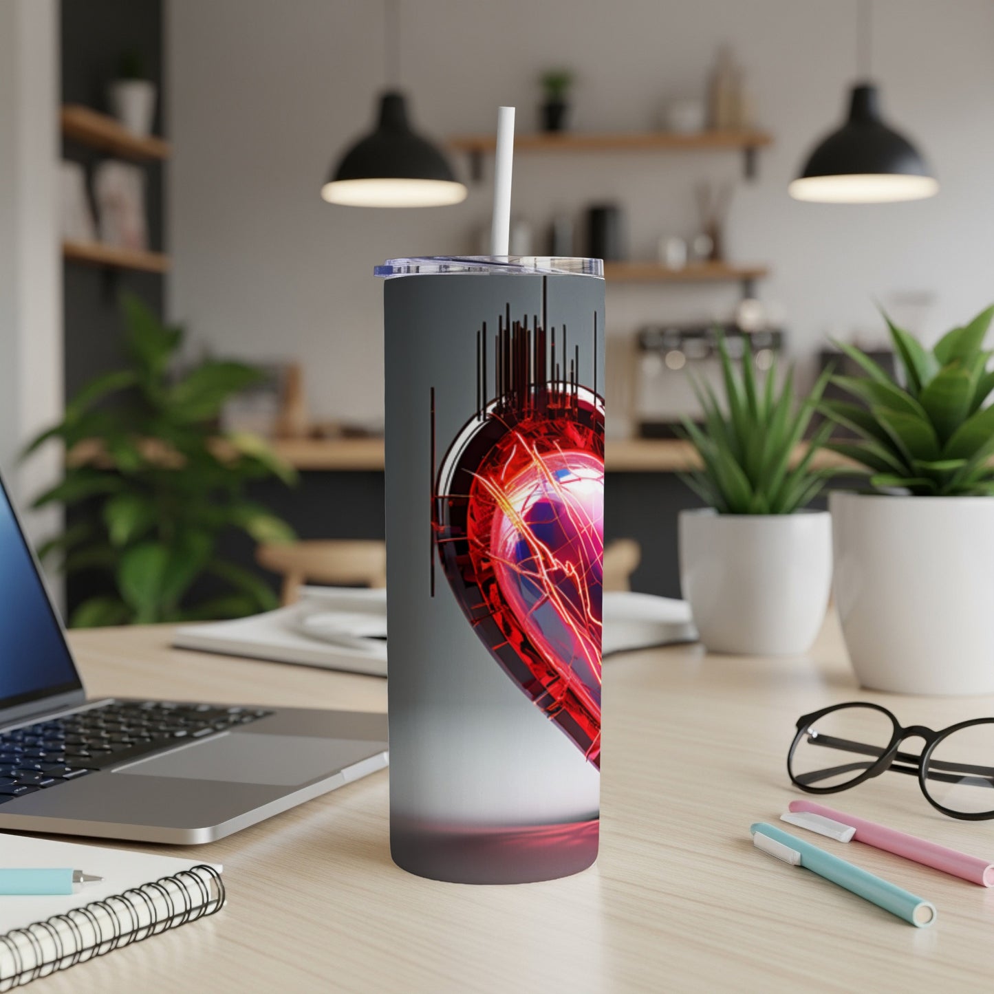 Heart-themed insulated tumbler with a straw on a desk.