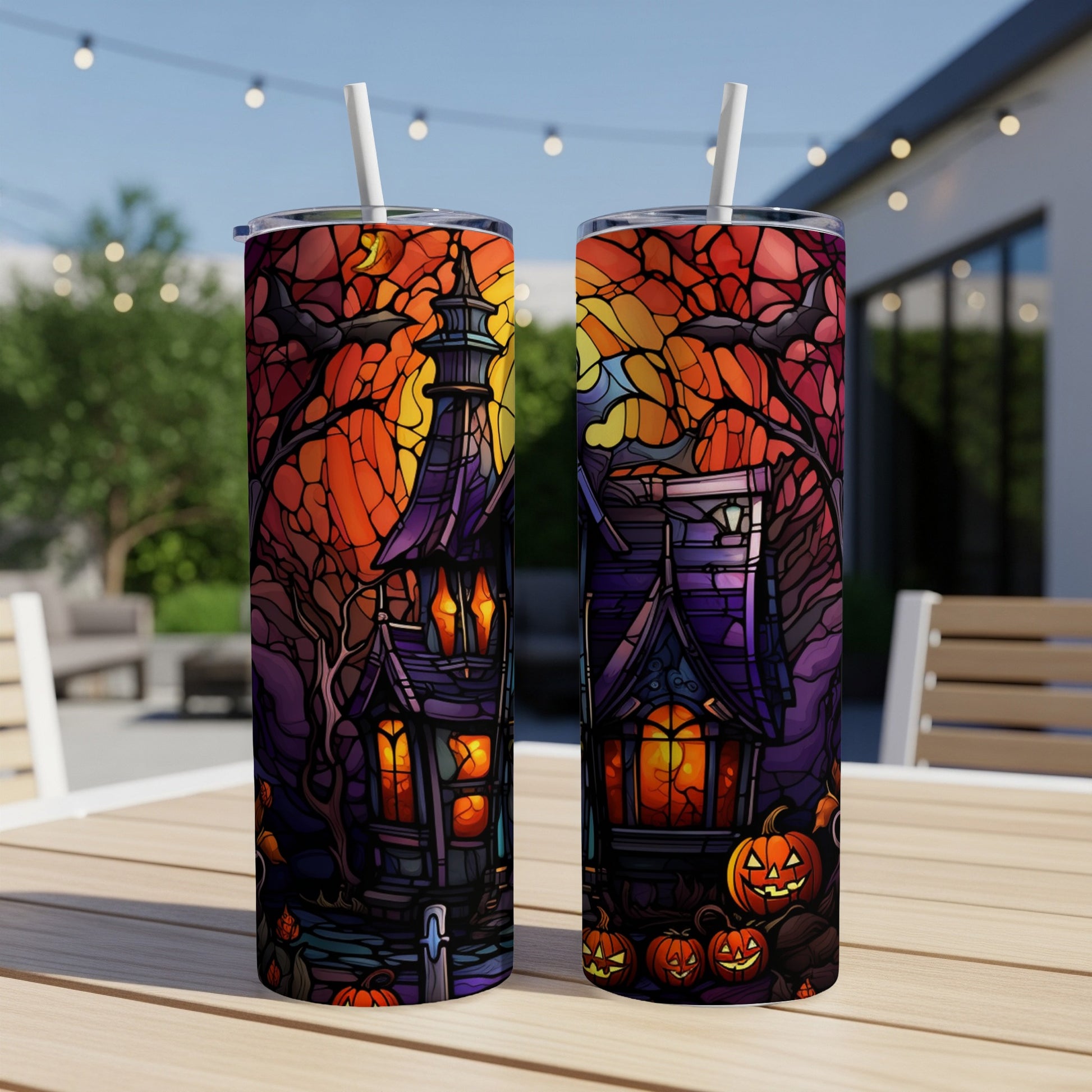 Two Halloween-themed tumblers with haunted houses, pumpkins, and bats.