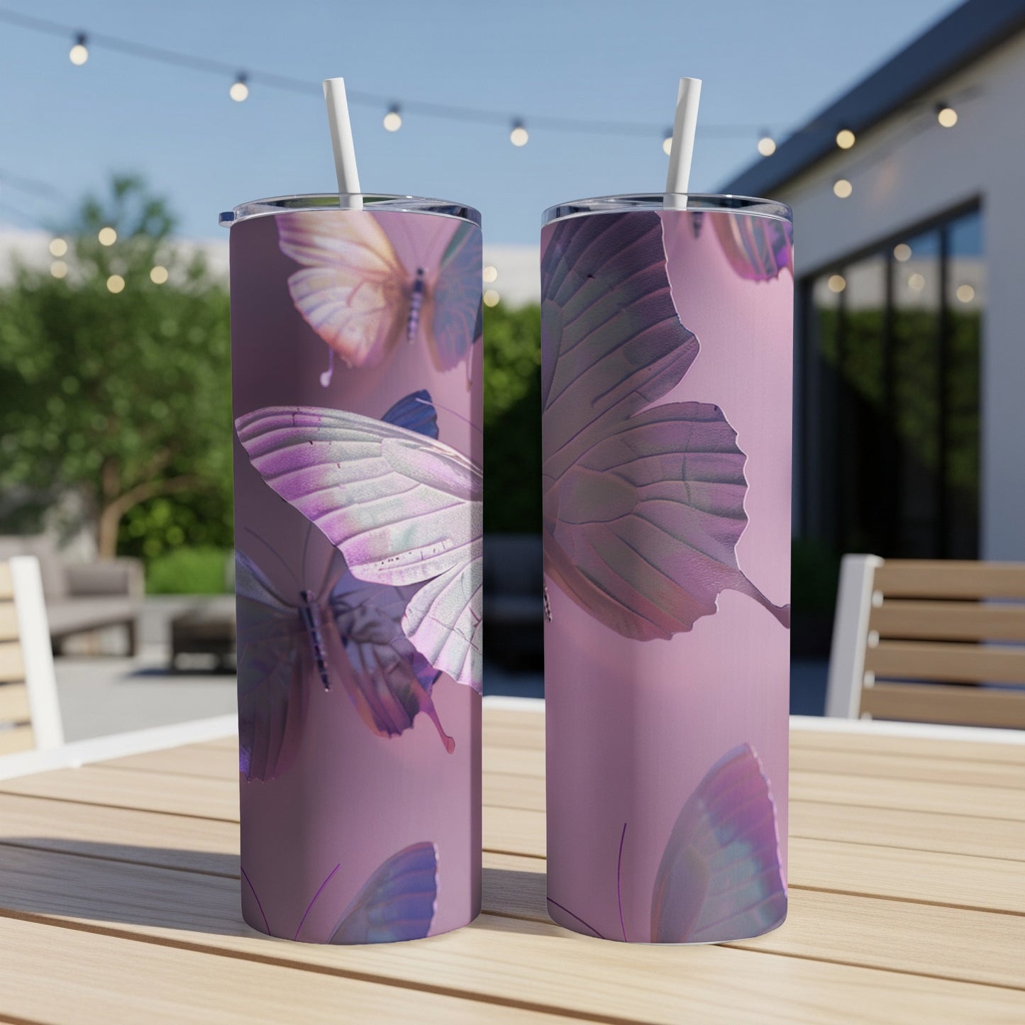 Two tall tumblers with iridescent butterfly wings design on a table.