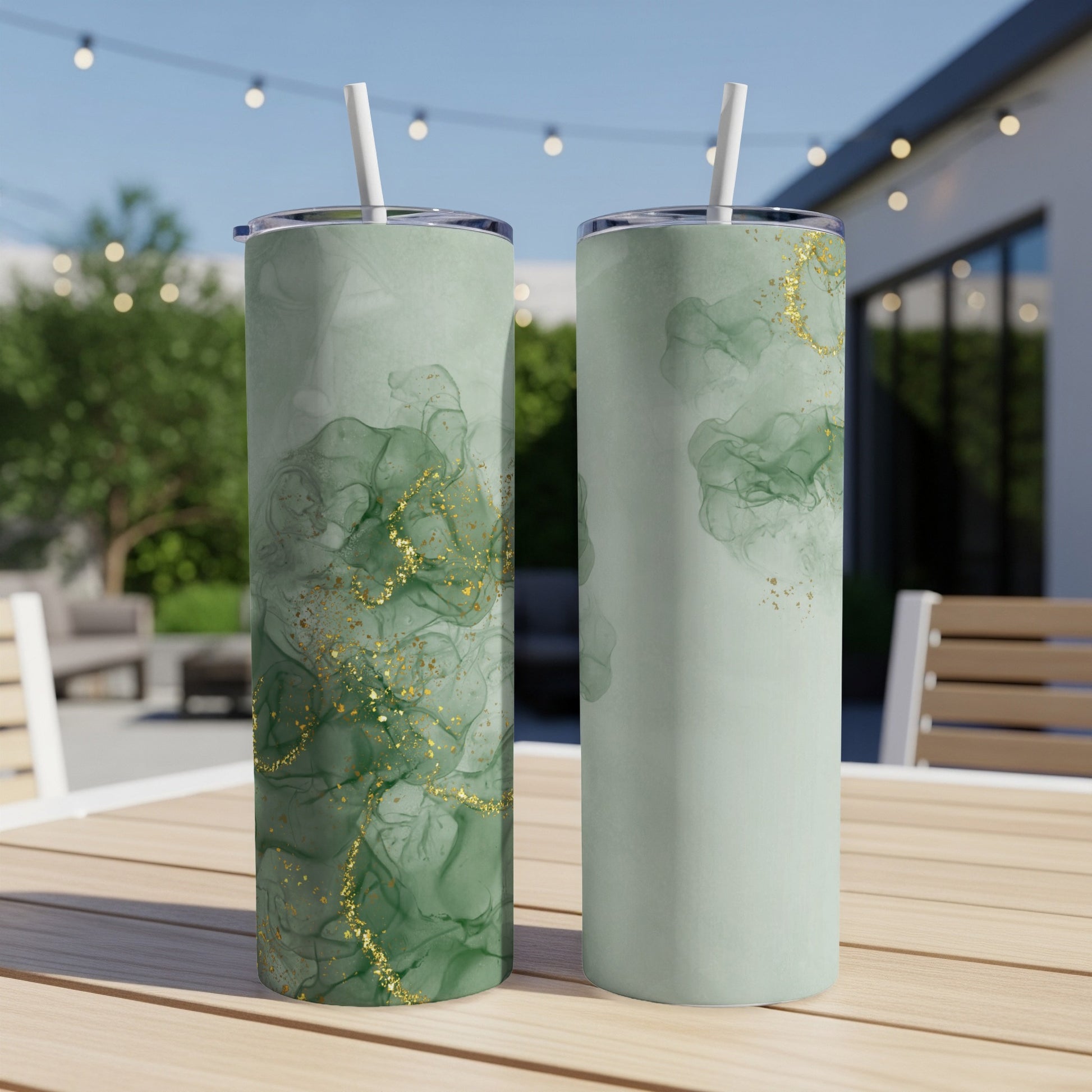 Two green tumblers with gold accents on a table.
