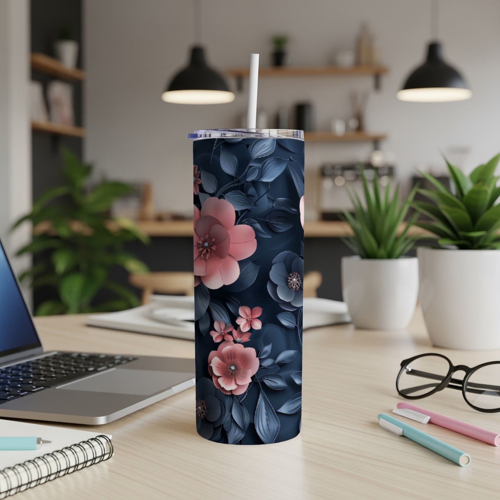 Dark navy tumbler with pink and blue floral pattern on a desk.