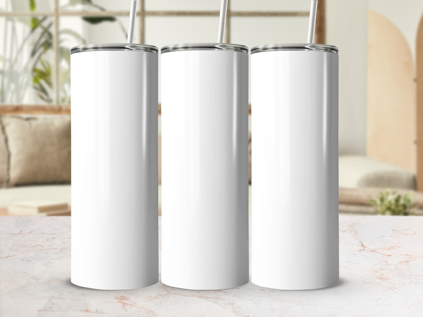 Three blank white tumblers with metal lids and straws arranged side-by-side.