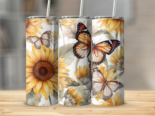 Three tumblers with sunflowers and monarch butterflies against a blurred background.